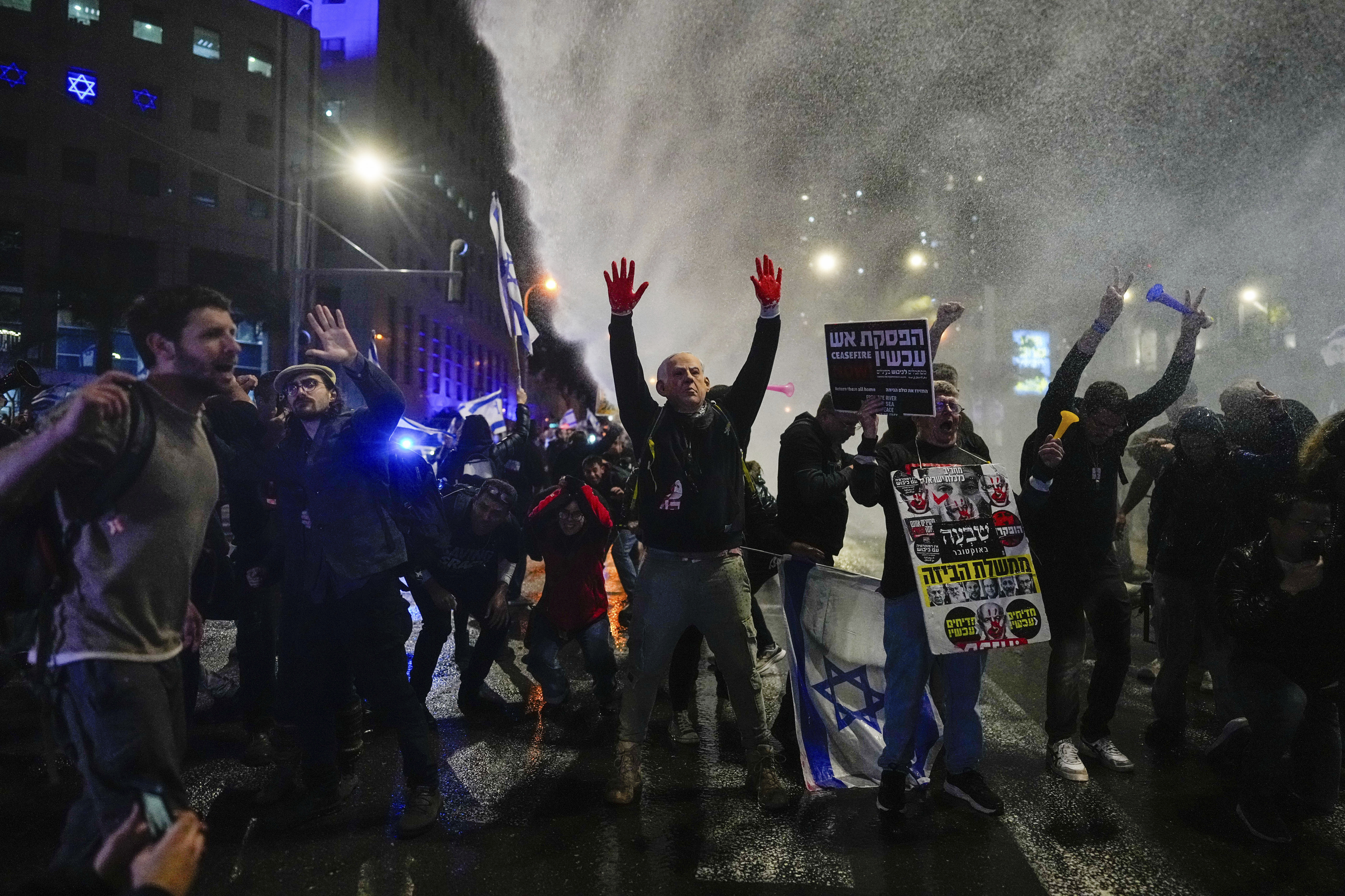 Police use water cannons to disperse demonstrators during a protest against Israeli Prime Minister Benjamin Netanyahu's government, and calling for the release of hostages held in the Gaza Strip by the Hamas militant group, in Tel Aviv, Israel, Saturday, Feb. 24