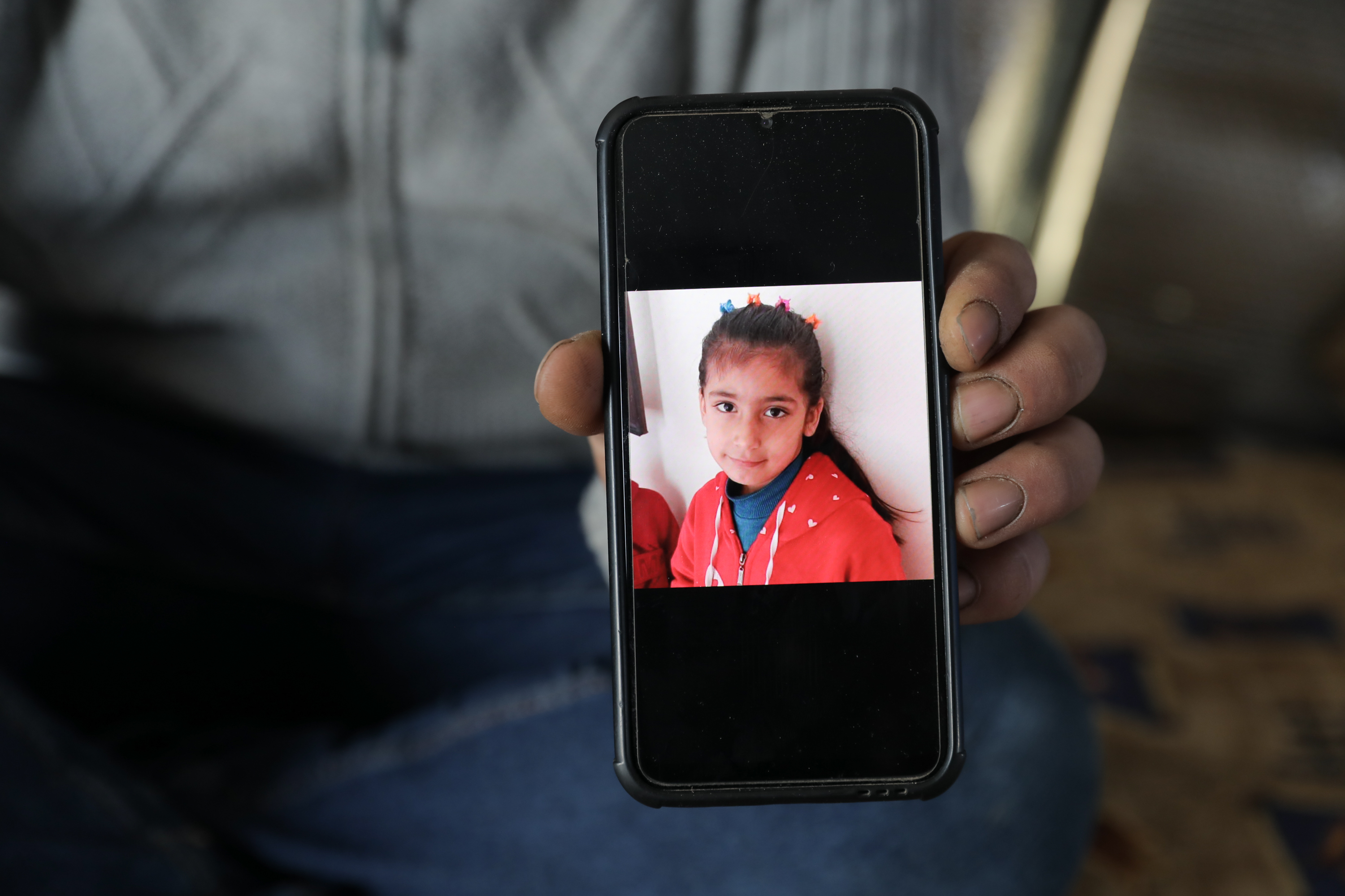 Ibrahim holds phone with photo of Ghazal