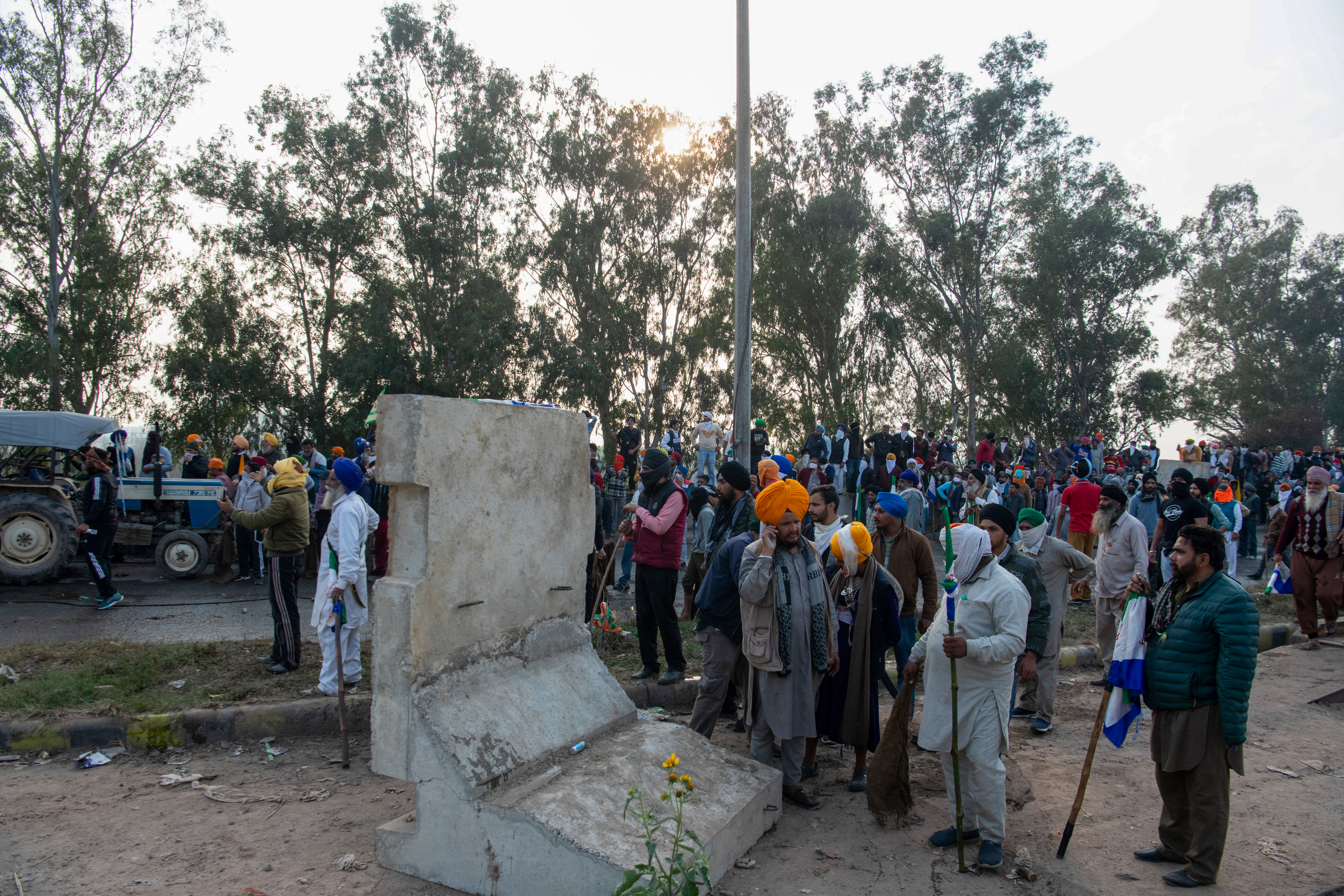 Farmers remove the concrete barricade near the Sandhu border to advance towards Delhi, despite authorities placing multiple layered barricades and iron nails to hinder their progress.