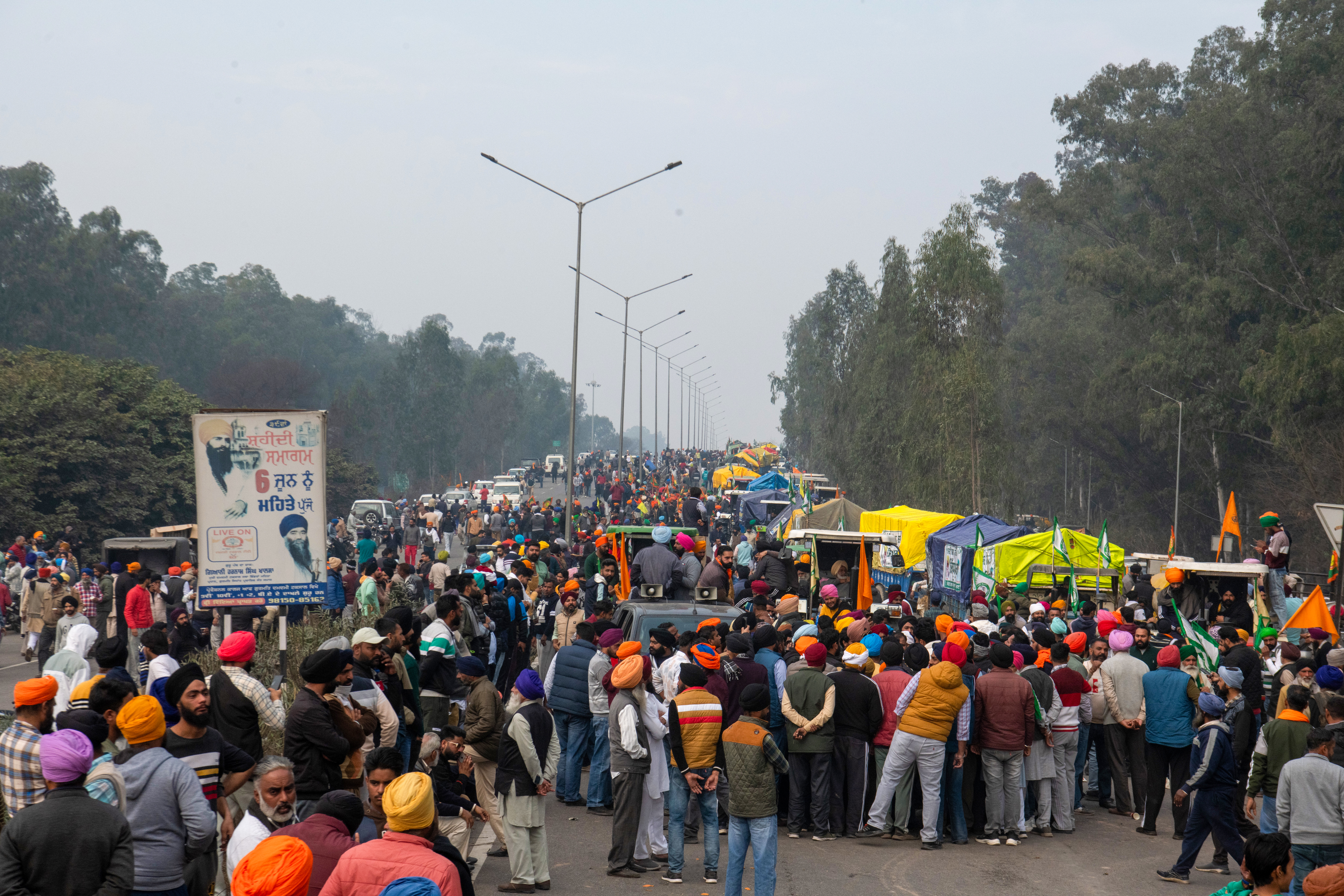 Farmers, along with a caravan of trucks, tractors, and water tankers, gather at Shambu village in Patiala district