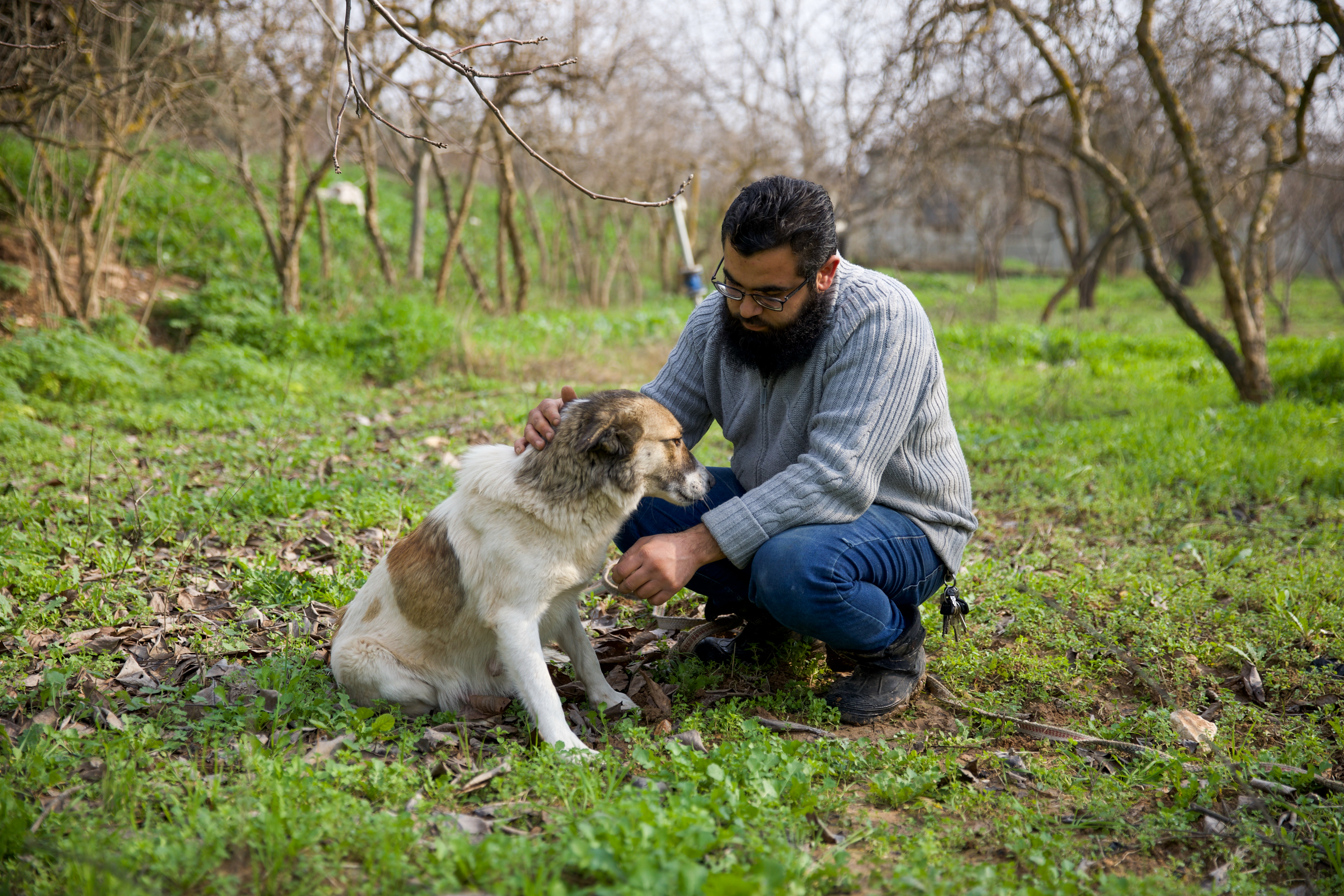 Ibrahim playing with Tiki the dog in a garden