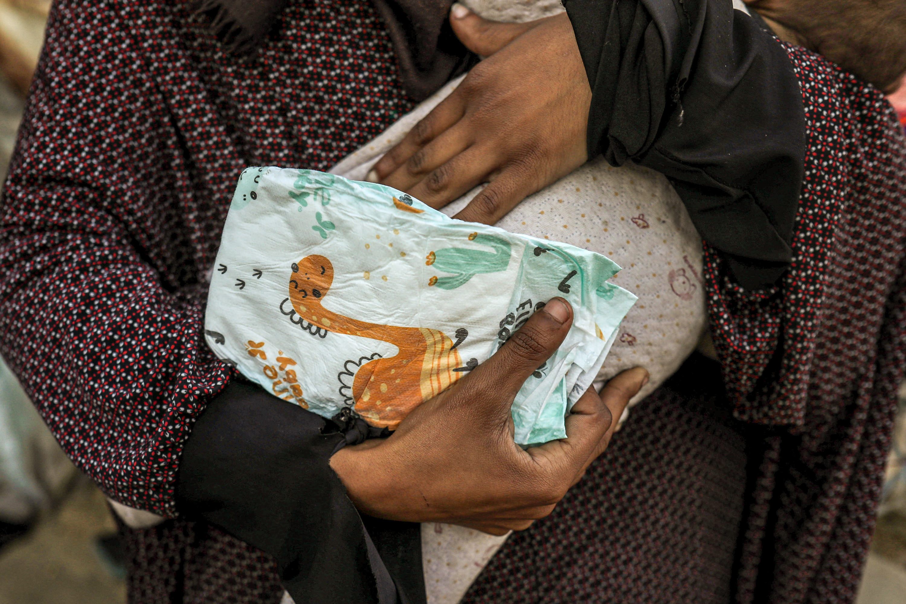 hands holding a baby and one nappy
