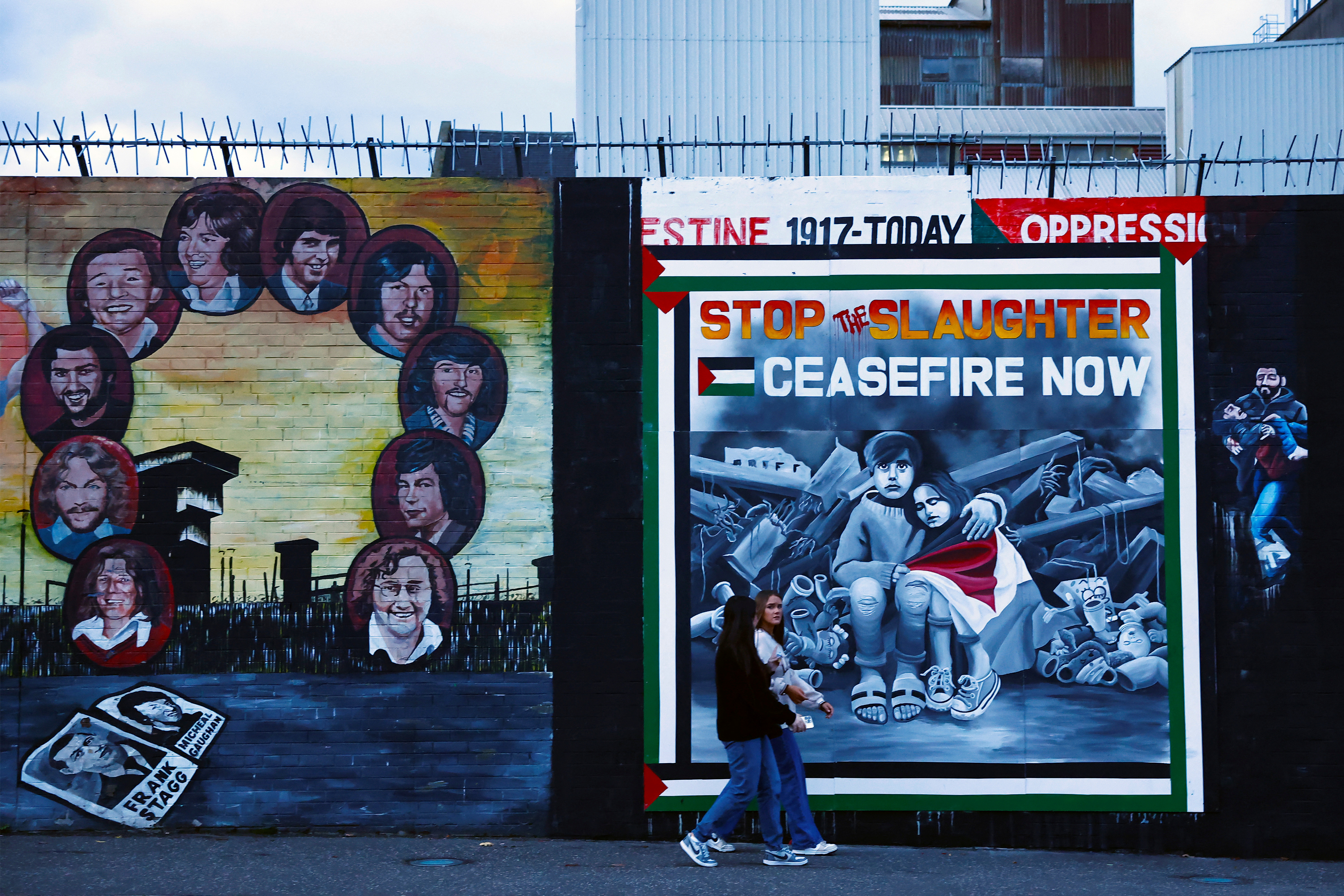 People walk past a mural in solidarity with Palestinians in Gaza, amid the ongoing conflict between Israel and Hamas, along the International Wall in the Nationalist area on the Falls Road in Belfast, Northern Ireland, November 4