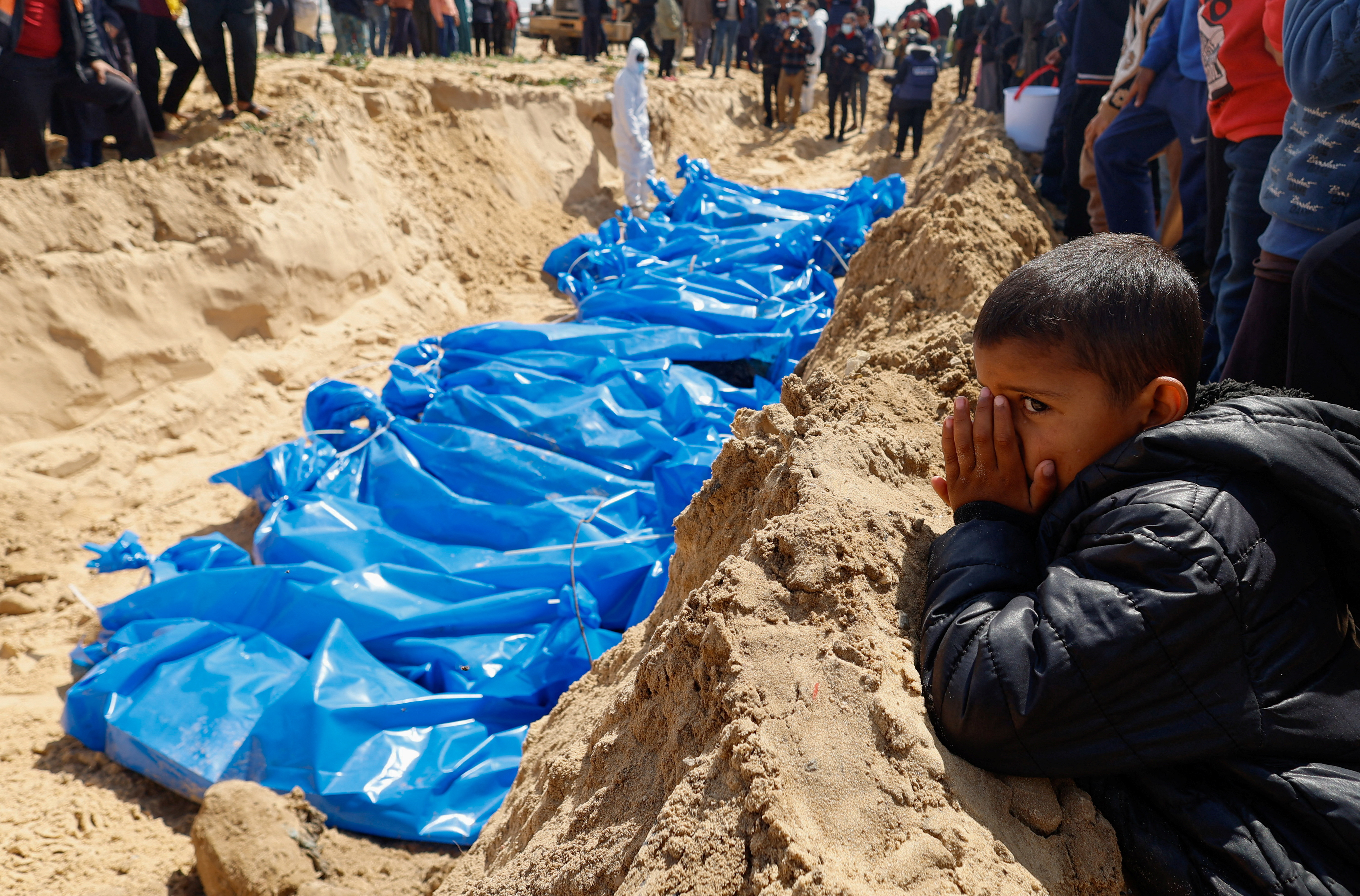 people bury the bodies of Palestinians