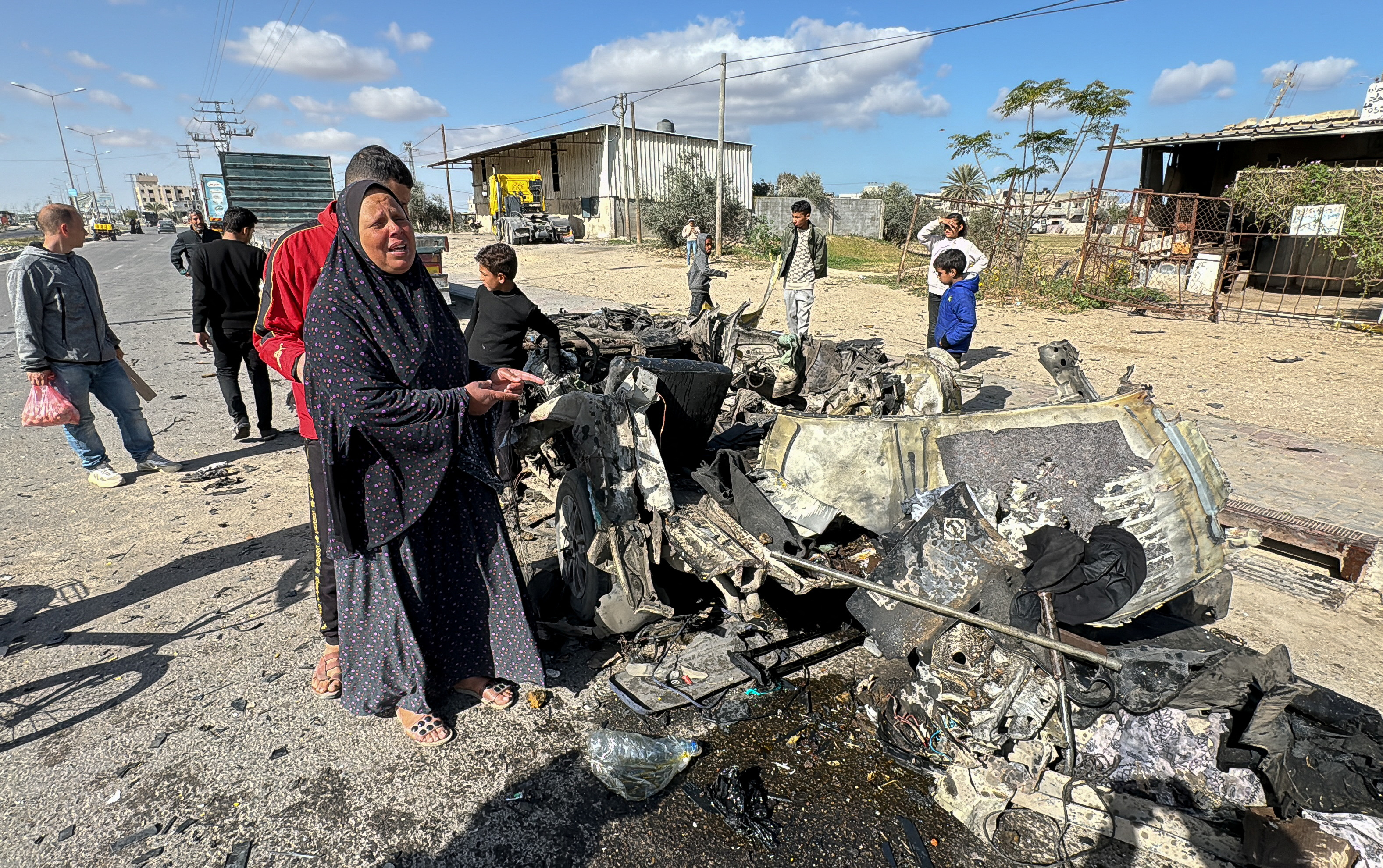 Palestinians gather at the site of an Israeli strike on a car, amid the ongoing conflict between Israel and the Palestinian group Hamas