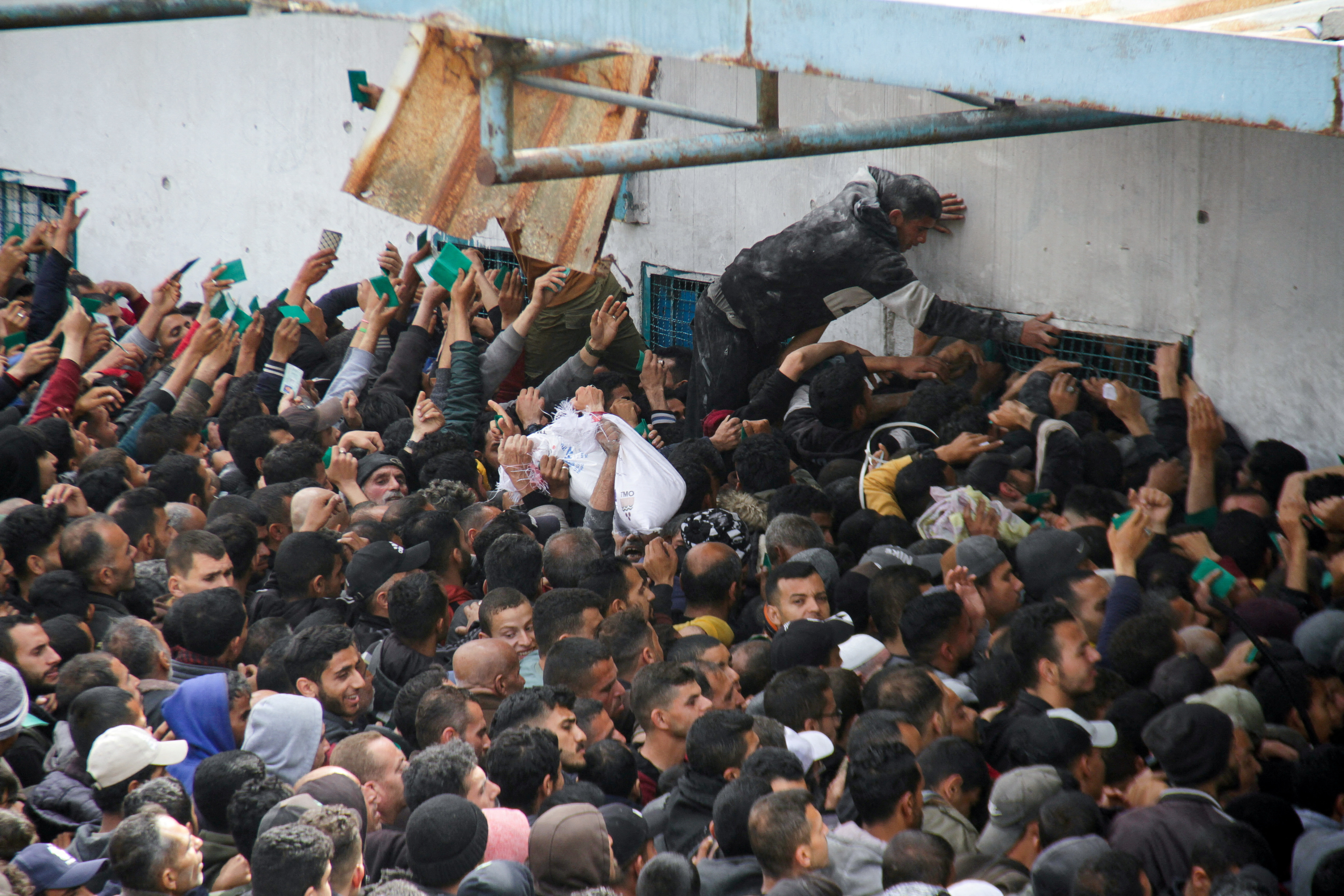 Palestinians gather to receive aid outside an UNRWA warehouse as Gaza residents face crisis levels of hunger, amid the ongoing conflict between Israel and Hamas, in Gaza City March 18, 2024. REUTERS/Mahmoud Issa TPX IMAGES OF THE DAY