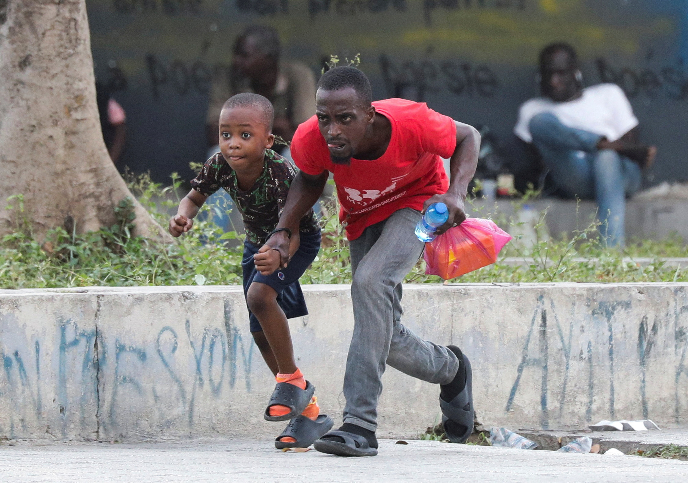 People take cover from gunfire near the National Palace, in Port-au-Prince