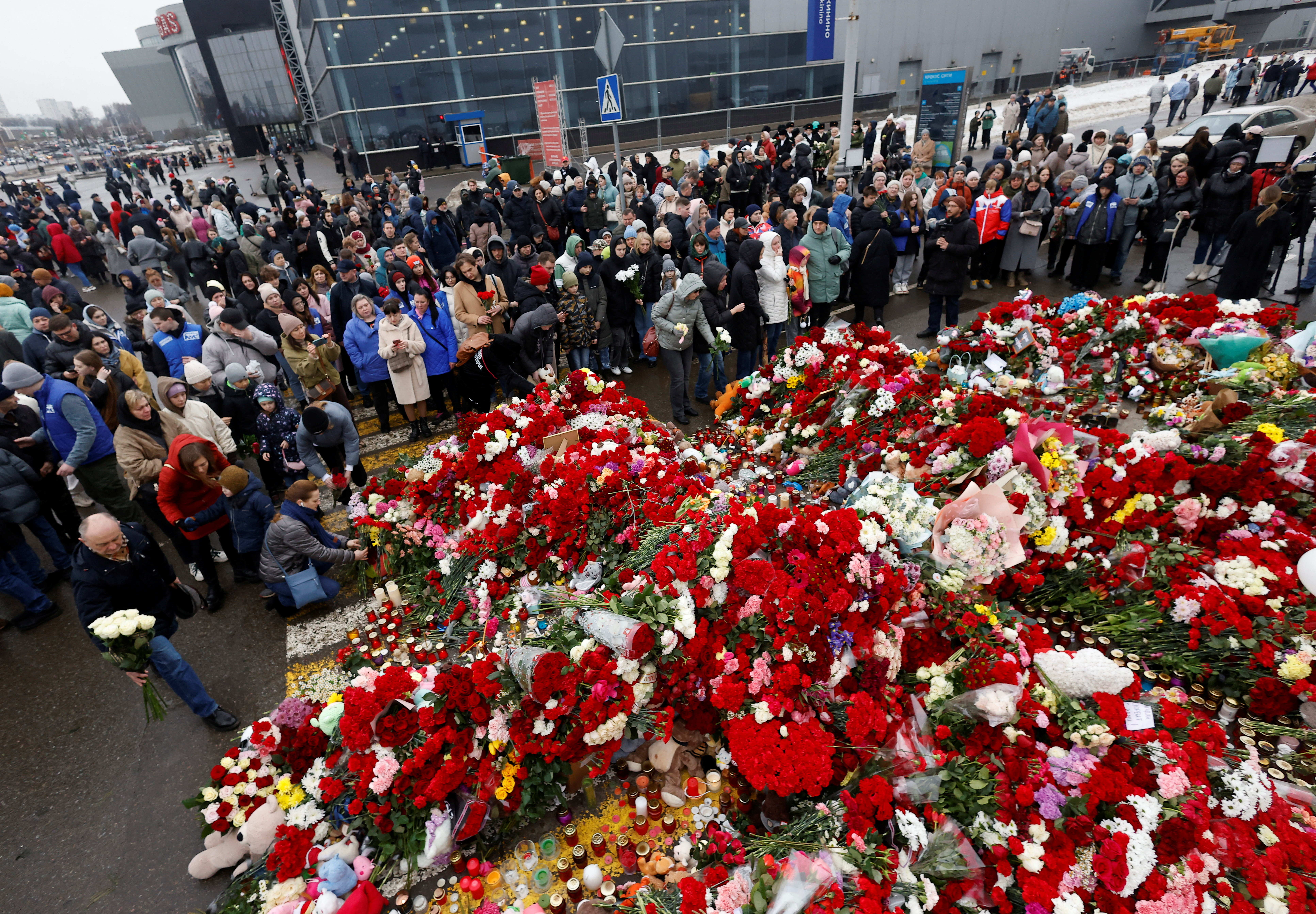 People gather at a makeshift memorial to the victims of a shooting attack set up outside the Crocus City Hall concert venue in the Moscow Region, Russia, March 24, 2024. REUTERS/Maxim Shemetov