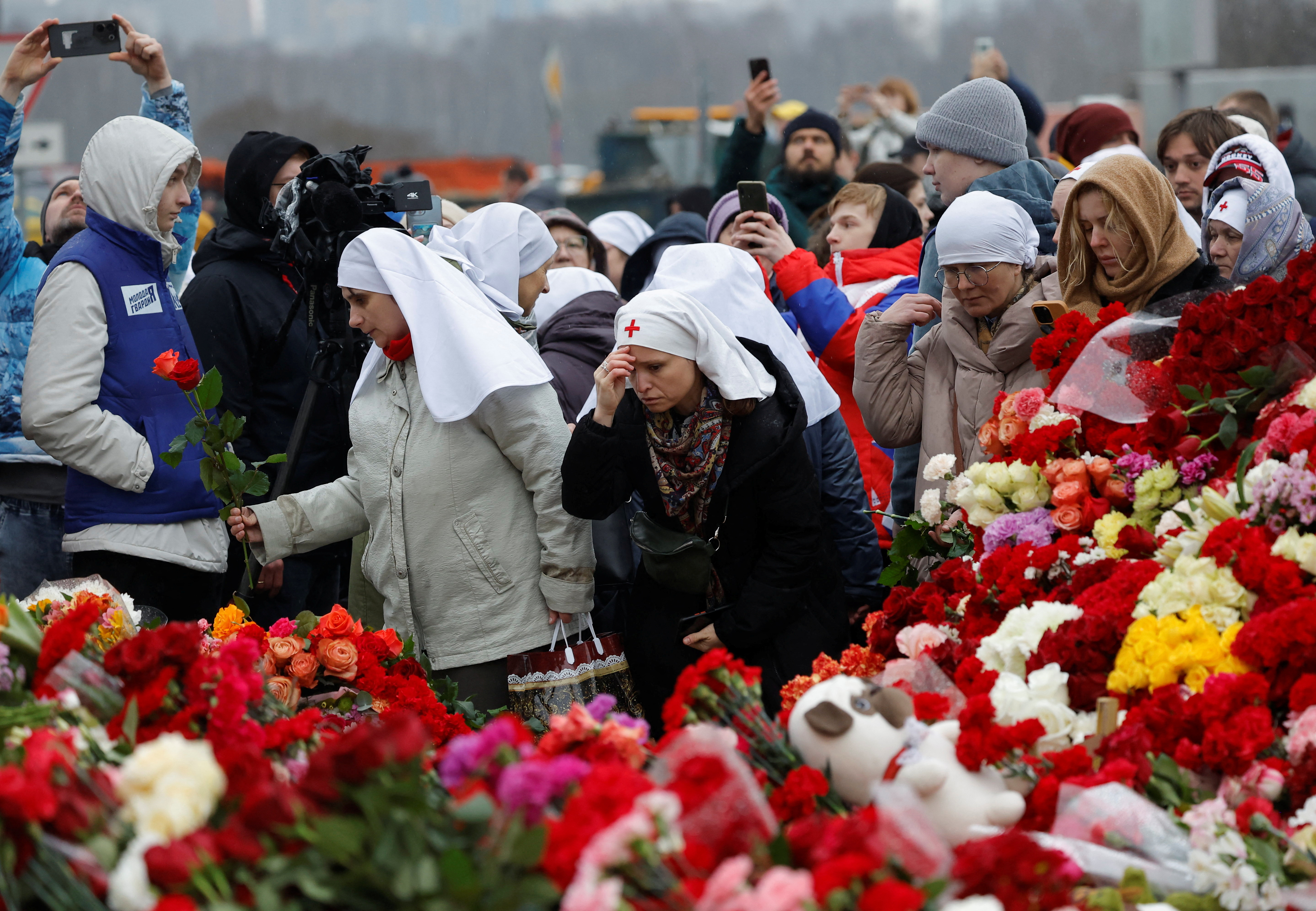 People lay flowers at a makeshift memorial to the victims of a shooting attack set up outside the Crocus City Hall concert venue in the Moscow Region, Russia, March 24, 2024. REUTERS/Maxim Shemetov