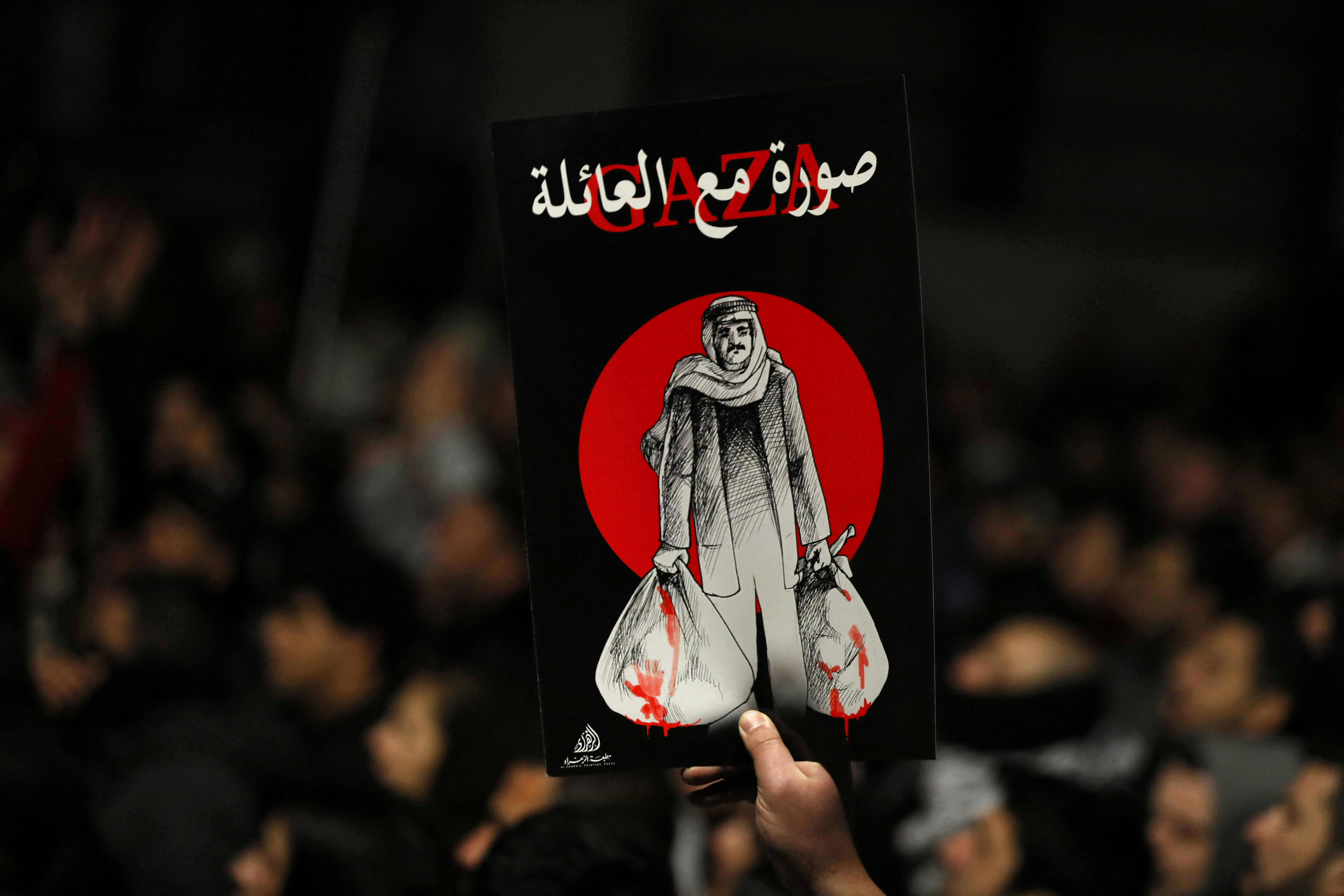 A demonstrator carries a placard during a protest in support of Palestinians in Gaza, amid the ongoing conflict between Israel and the Palestinian Islamist group Hamas, outside Al Kalouti mosque near the Israeli embassy in Amman, Jordan, March 27, 2024. REUTERS/Alaa Al-Sukhni