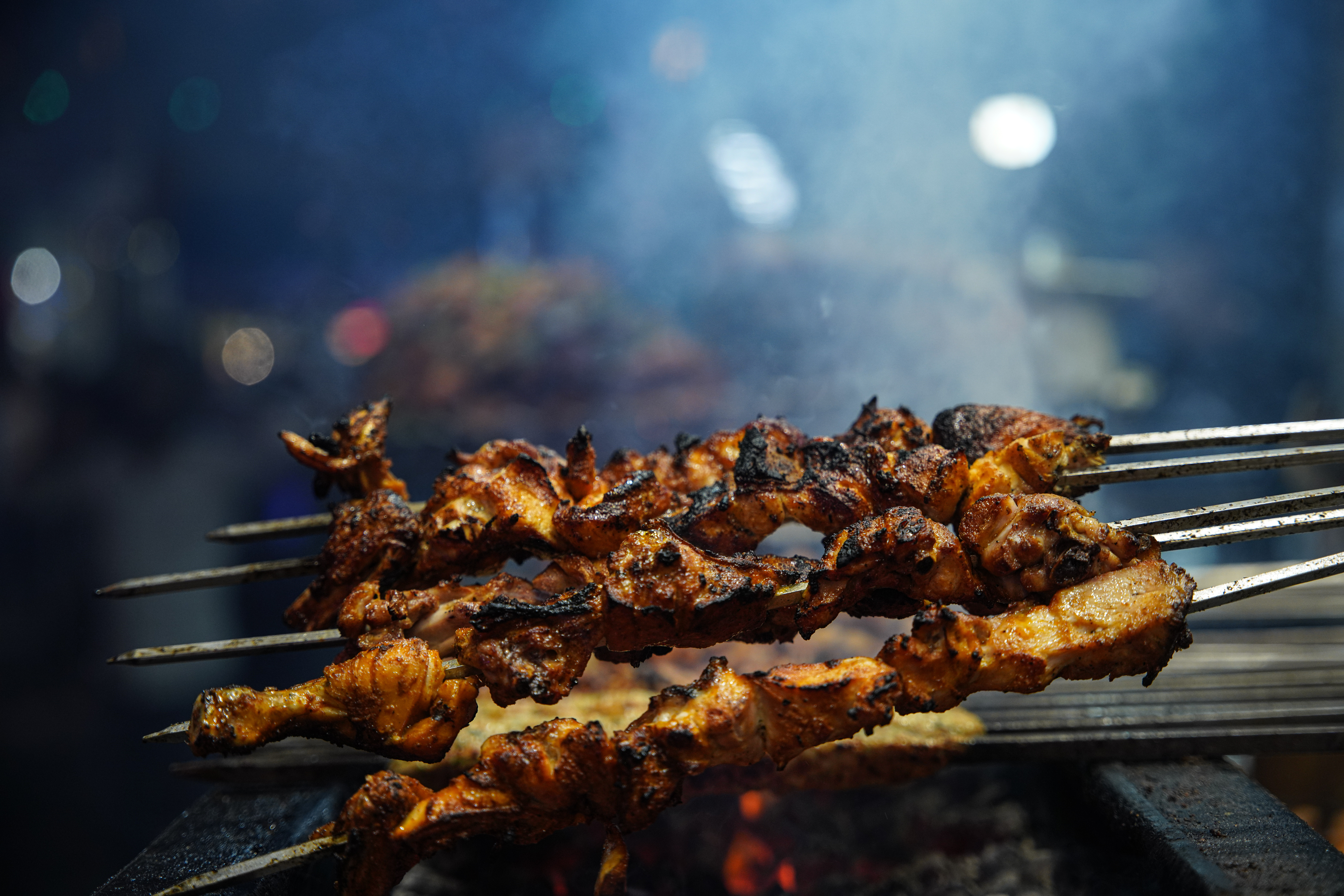 Wafts of smoke rise from a barbecue stall. [Meer Faisal/Al Jazeera]