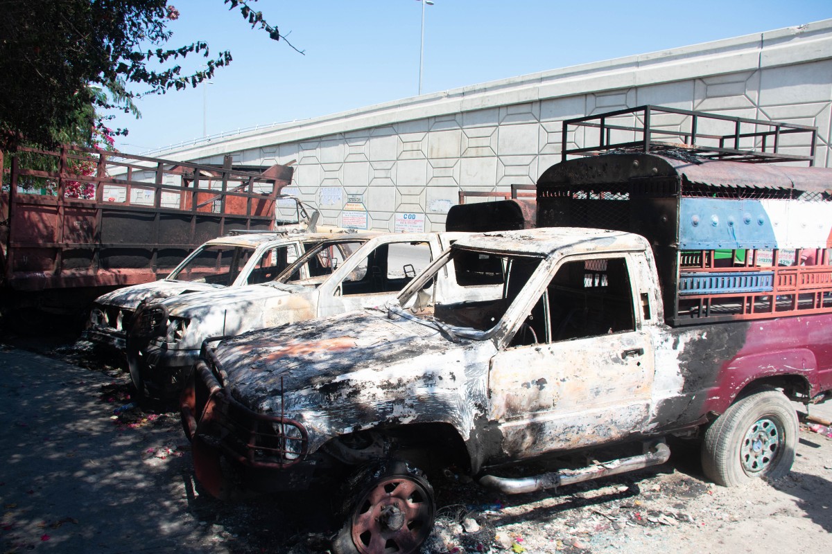 Carcasses of burnt-out vehicles are seen in front of the police station at Carrefour de lAeroport, in Port-au-Prince