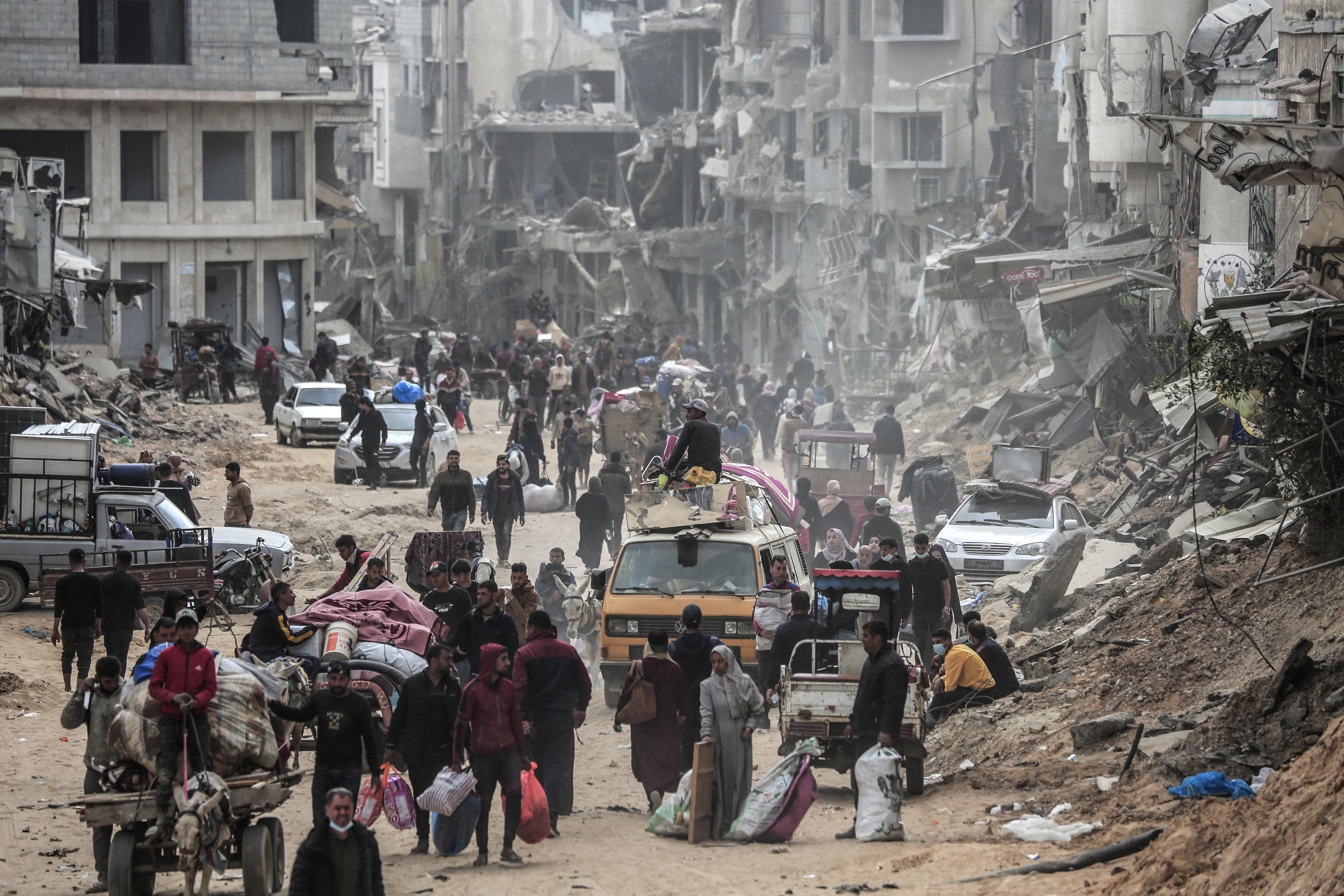 Displaced Palestinians carry their belongings through a street in Khan Yunis in the southern Gaza Strip