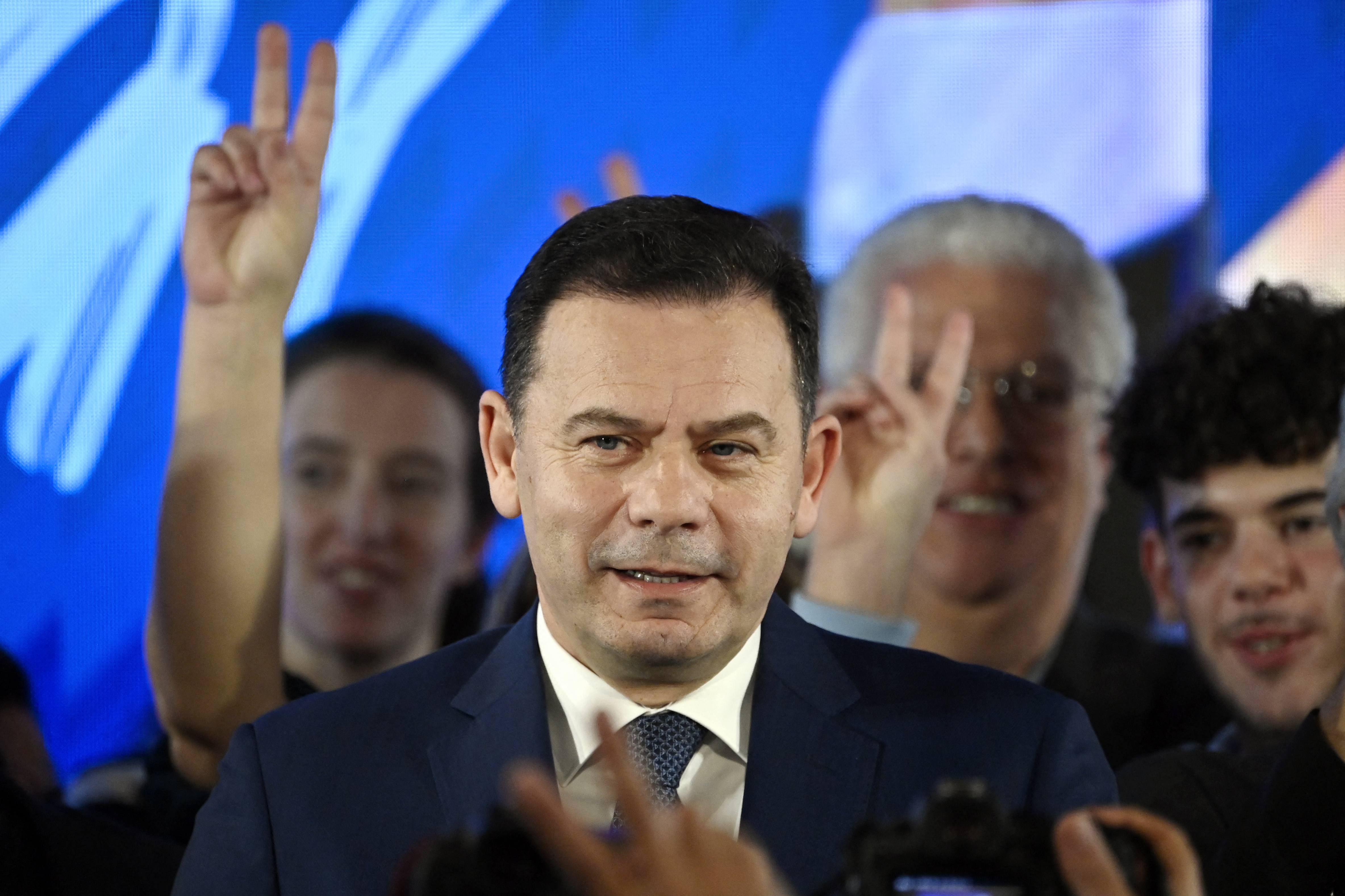 Democratic Alliance (AD) leader Luis Montenegro speaking to his supporters. Some are holding their fingers up in a 'V' for victory sign.