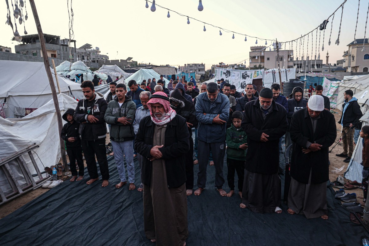 A displaced Palestinian man prays before breaking the fast