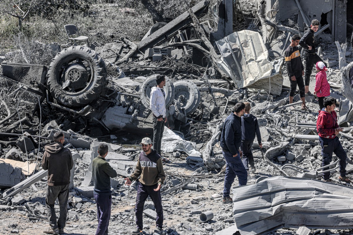 People inspect the rubble and debris of a building that collapsed following an Israeli air strike in the Rafah refugee