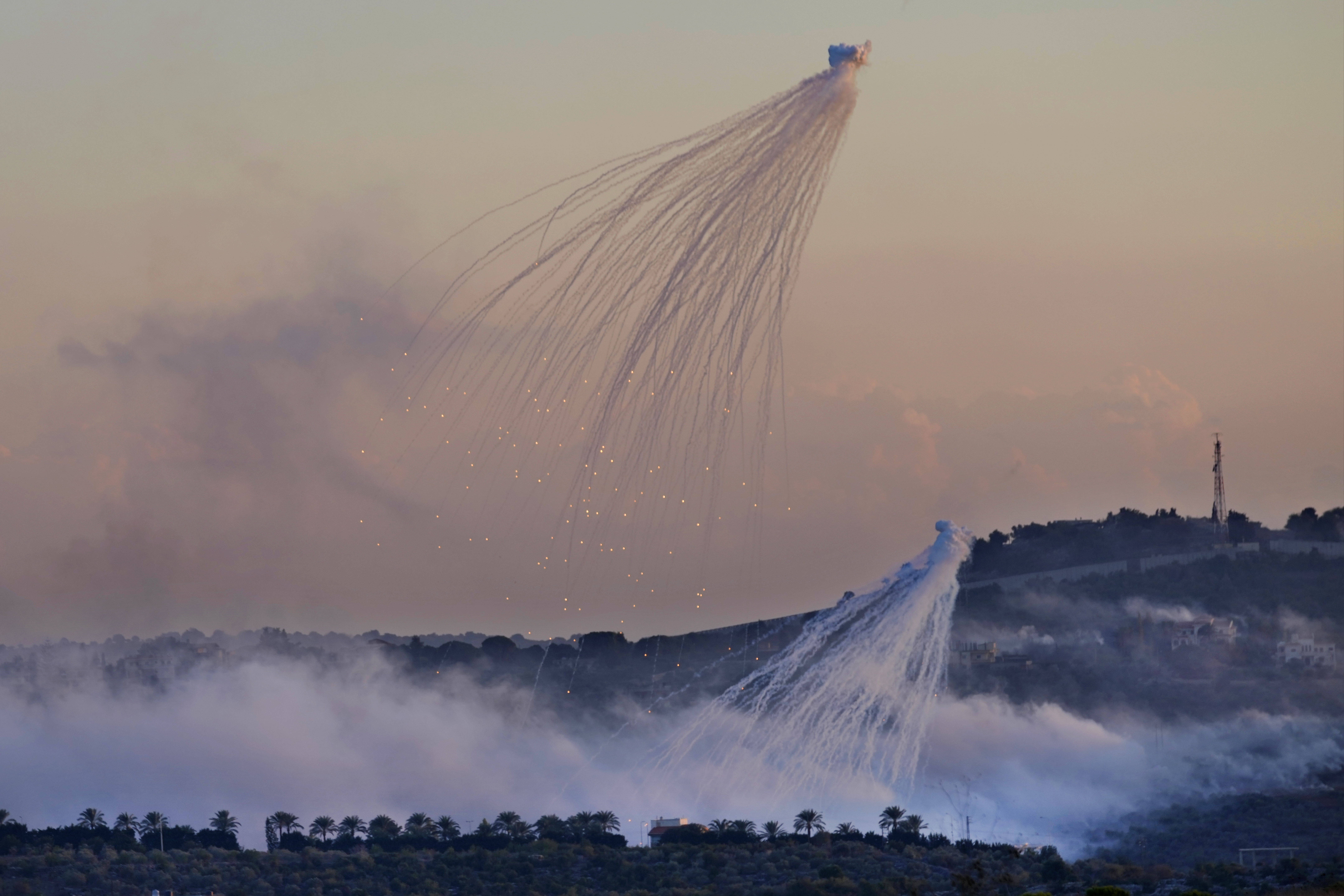 Two shells exploding intojellyfish above fields