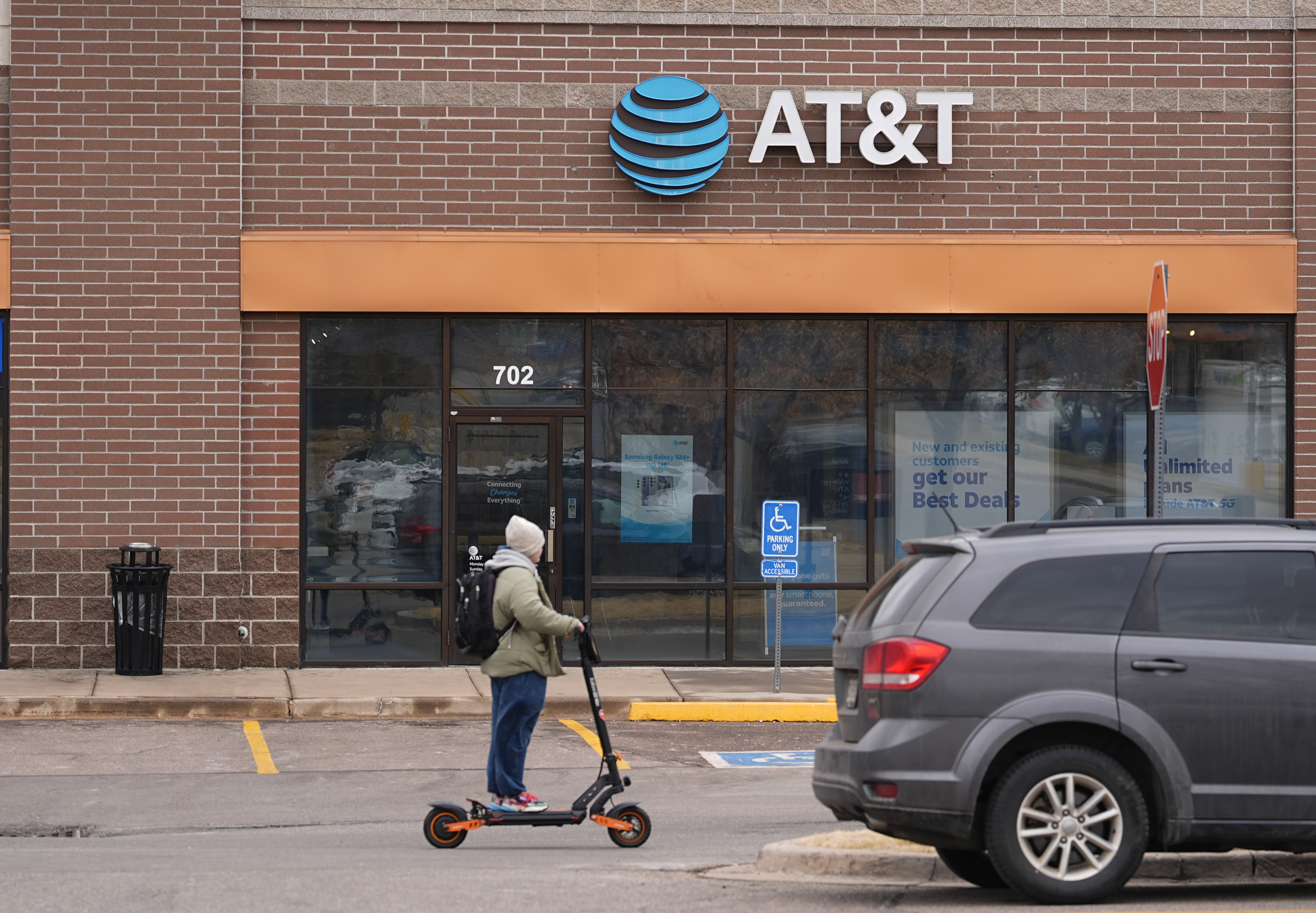 Man on scooter rides past AT&T store in Denver