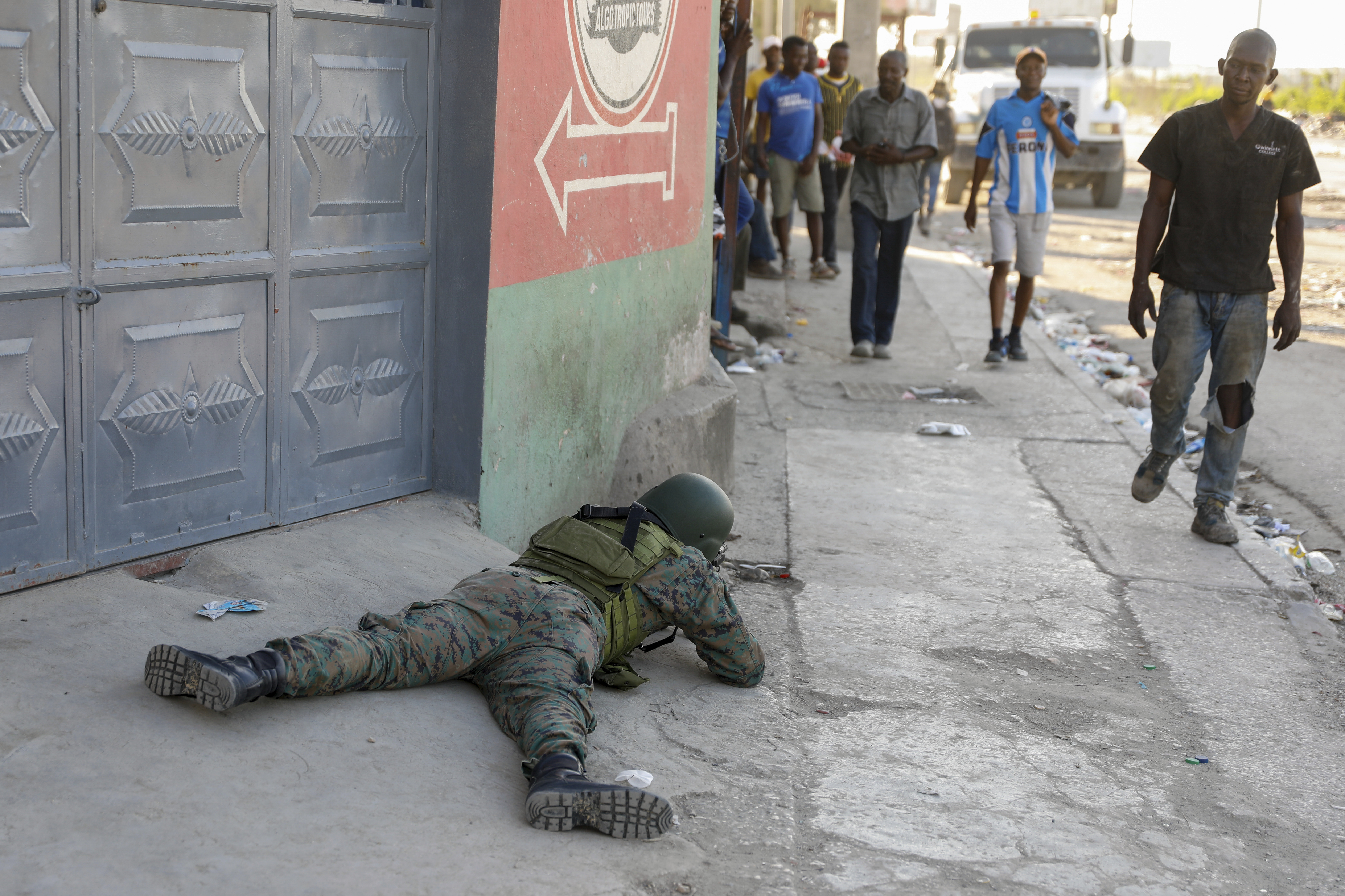 Pedestrians was past a soldier guarding the area of the international airport in Port-au-Prince,