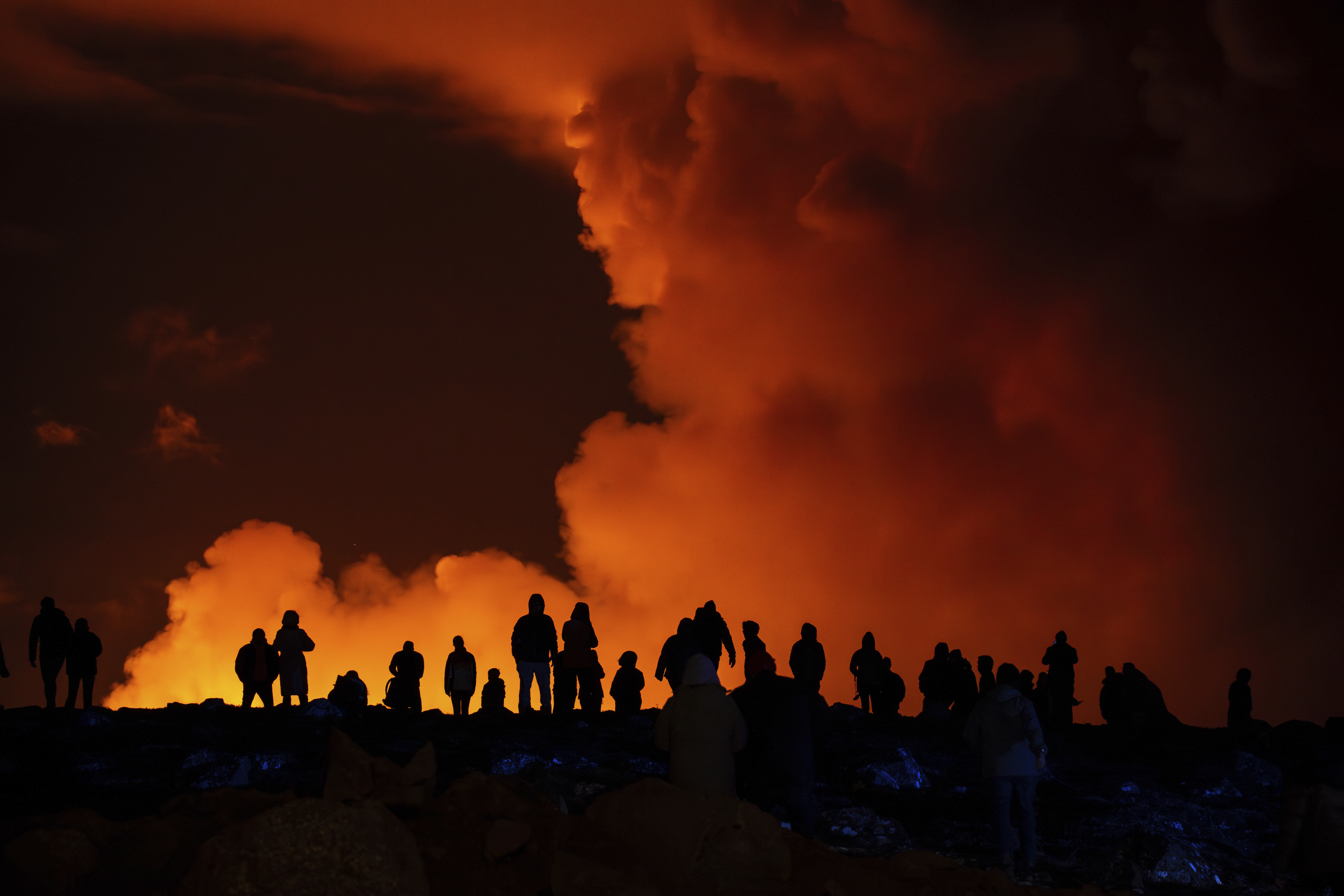 Spectators watch plumes of smoke from volcanic activity between Hagafell and Stóri-Skógfell, Iceland, Saturday, March 16