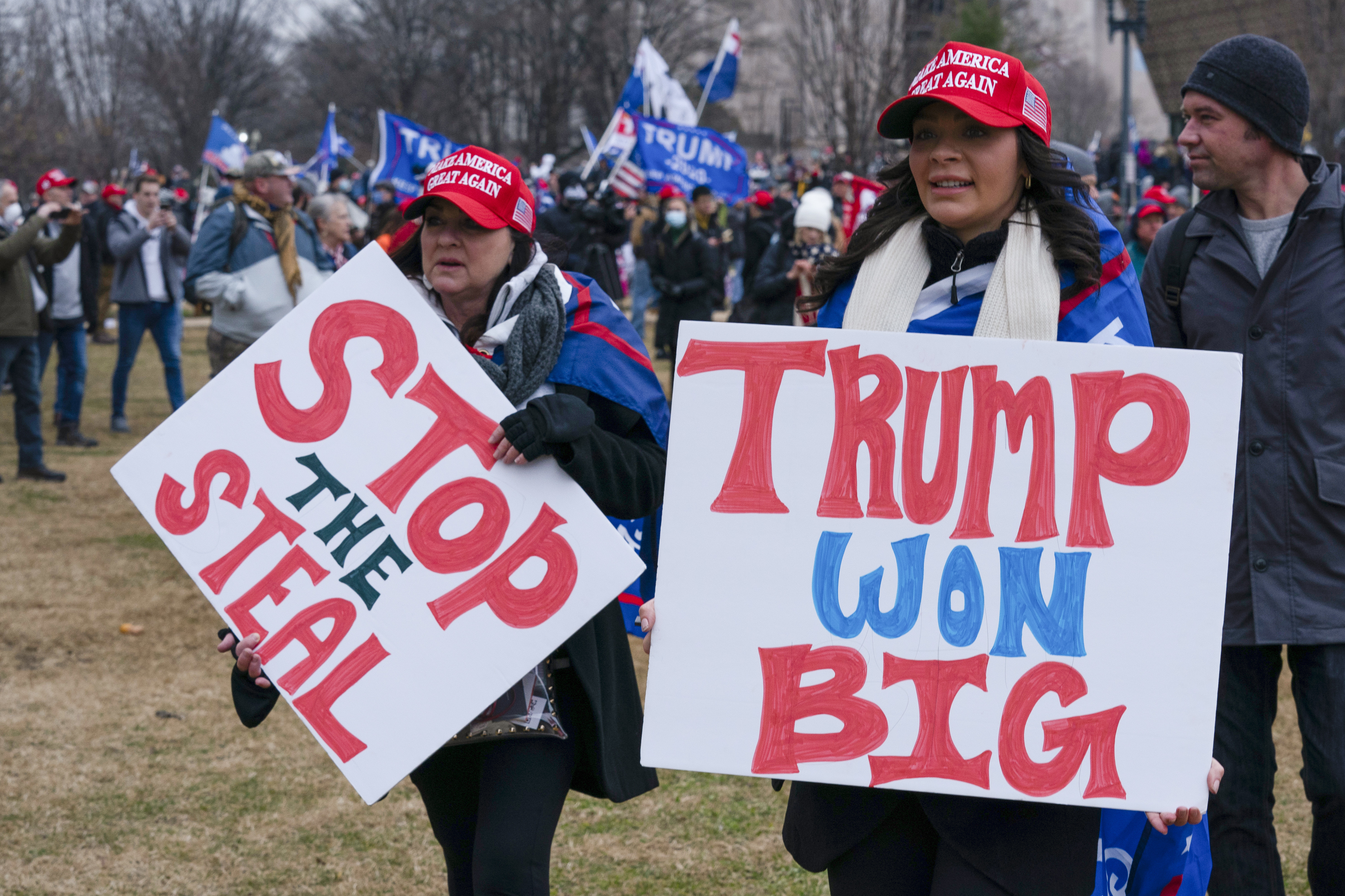 Trump supporters on January 6 hold signs that read "Stop the Steal" and "Trump won big."