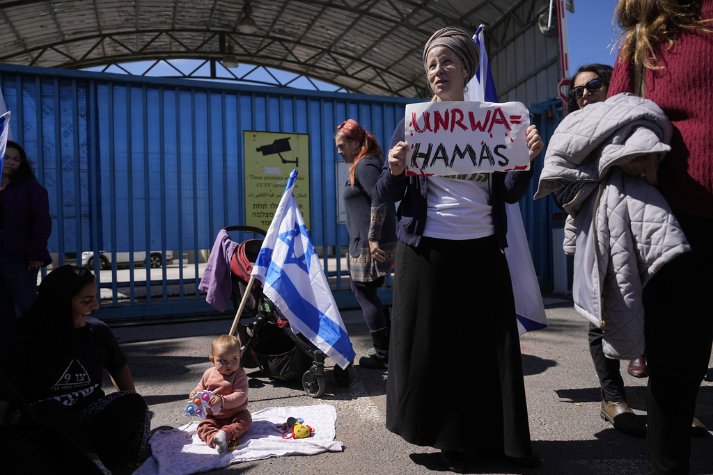 Israelis block the entrance to UNWRA, the main U.N. agency providing aid in the Gaza Strip, during a protest in Jerusalem, Wednesday, March 20, 2024. The UNRWA agency is reeling from allegations that 12 of its 13,000 Gaza staff members participated in the Oct. 7 Hamas attacks in southern Israel. (AP Photo/Ohad Zwigenberg)