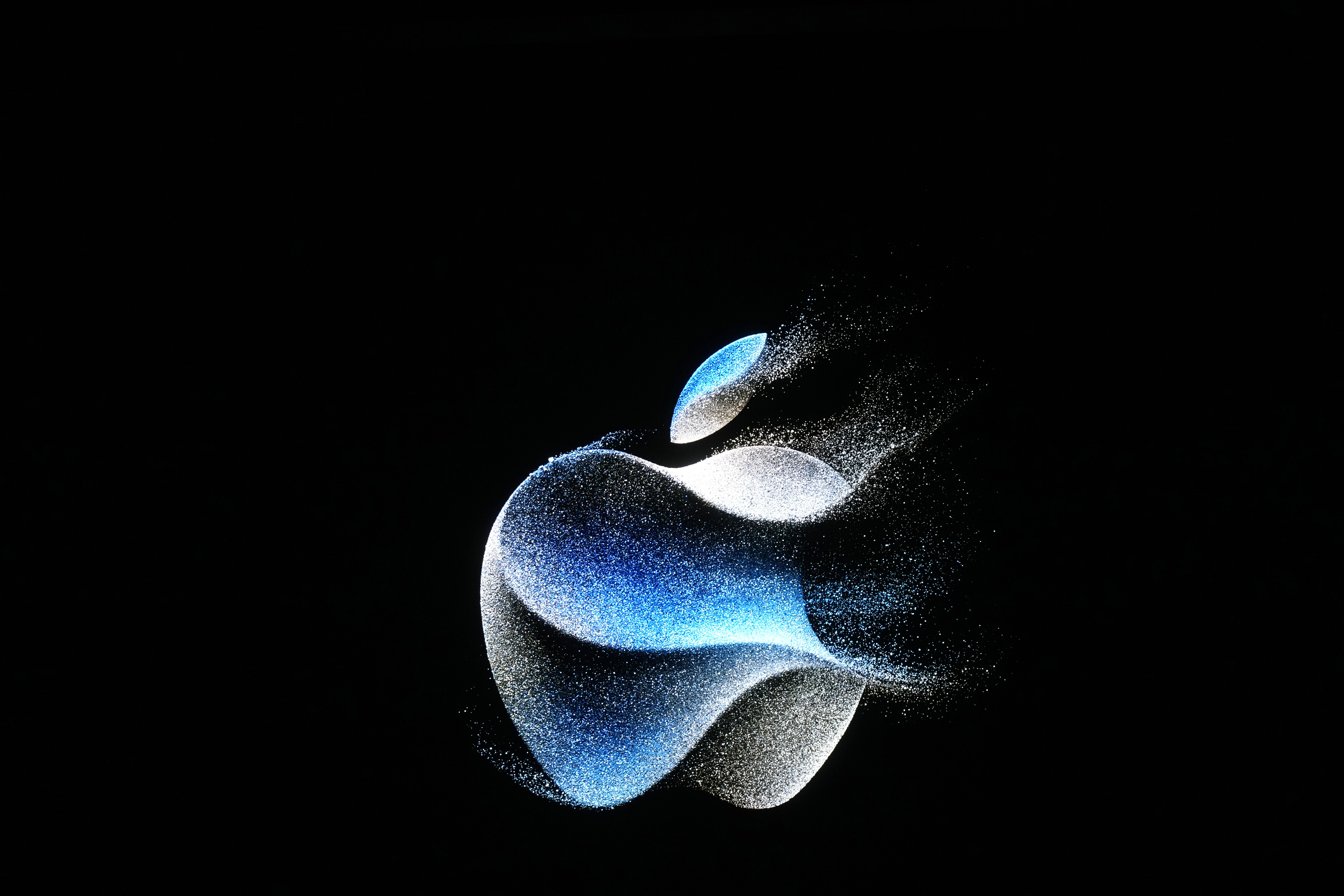The Apple logo is shown on a screen during an announcement