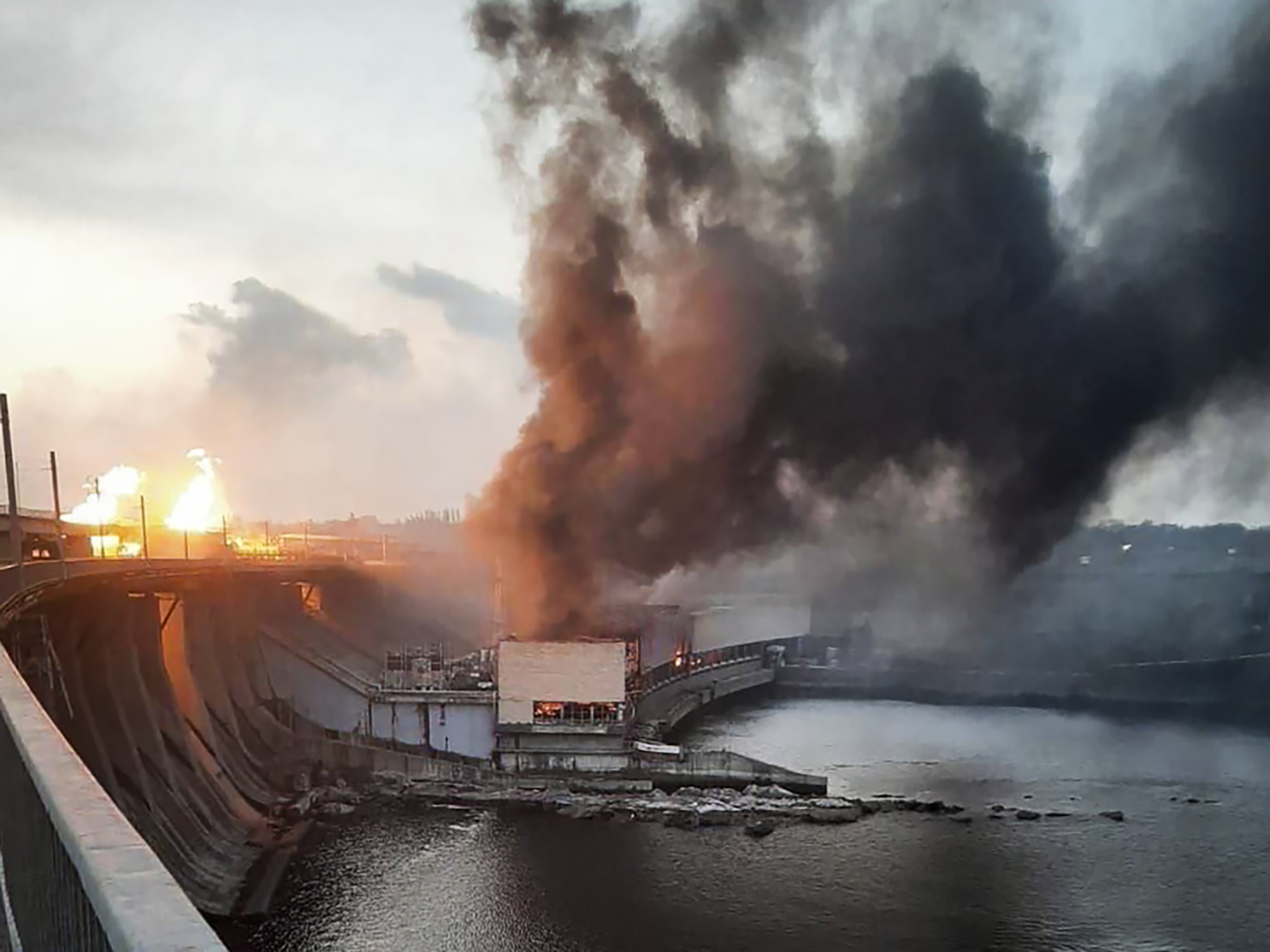 smoke and fire rise over the Dnipro hydroelectric power plant after it was hit by Russian missiles