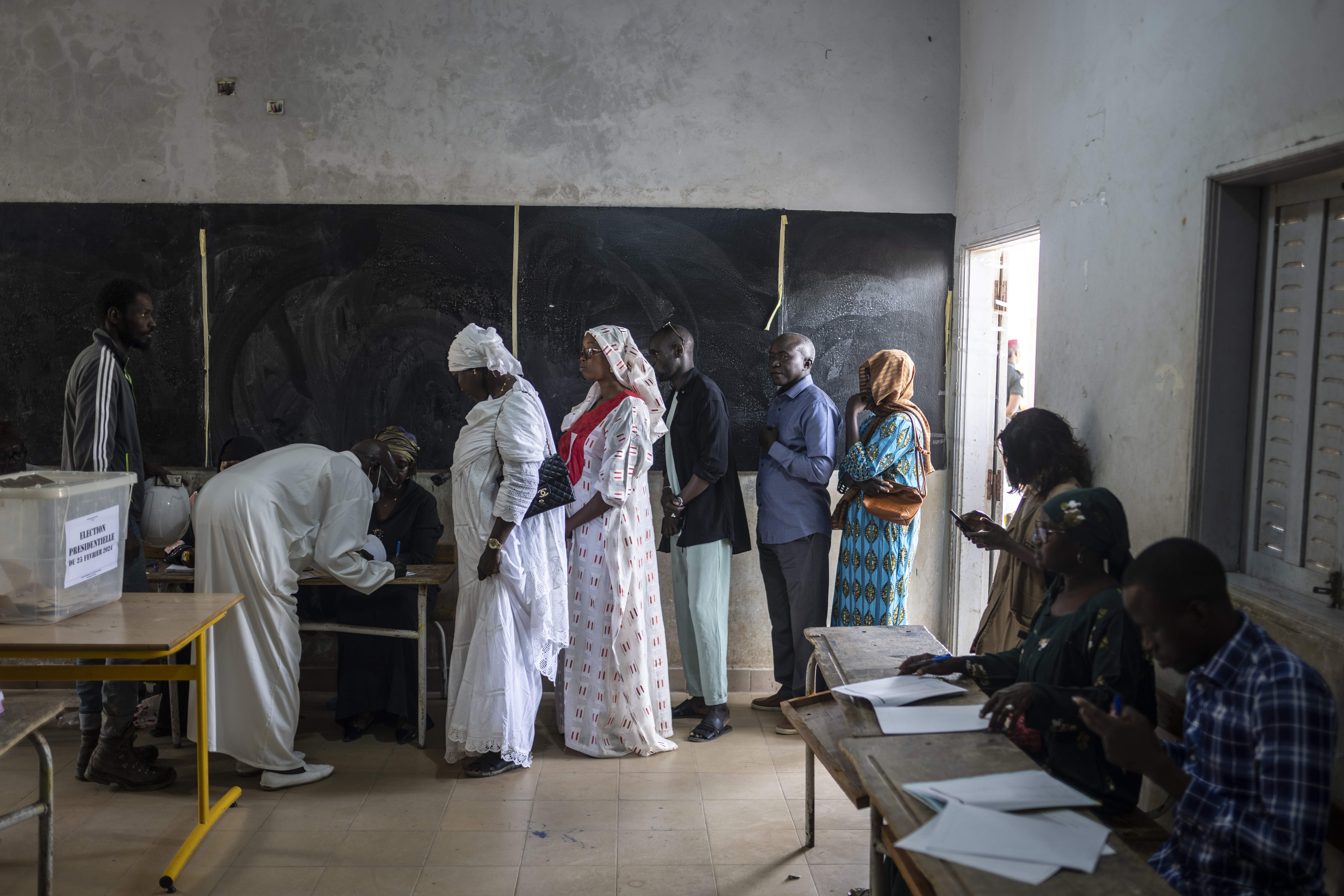 People wait to cast their votes inside a polling station during the presidential elections, in Dakar
