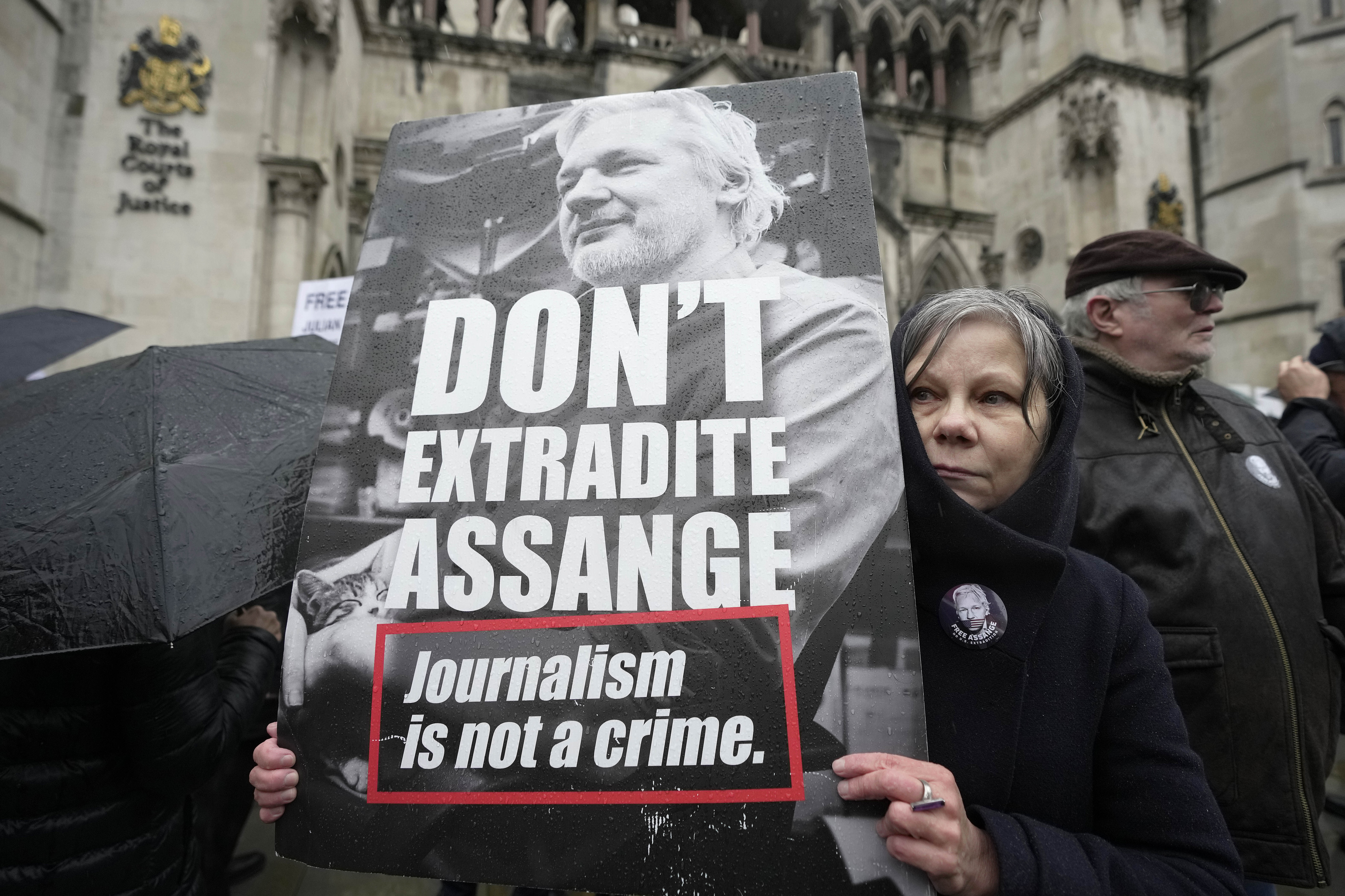 A protester holds a placard outside the Royal Courts of Justice in London