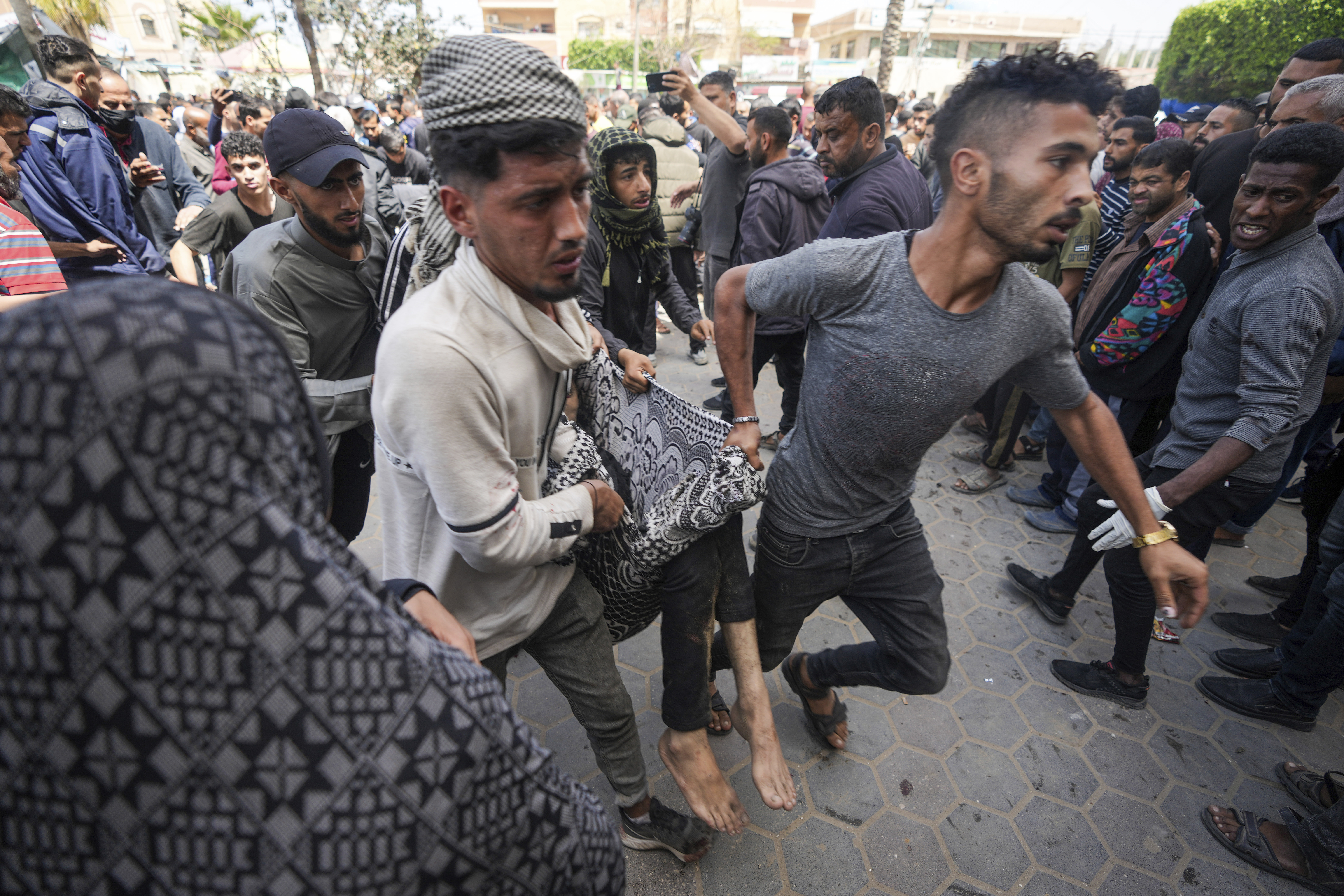 Palestinians carry a wounded person following an Israeli air attack near Al-Aqsa Hospital in Deir el-Balah, central Gaza