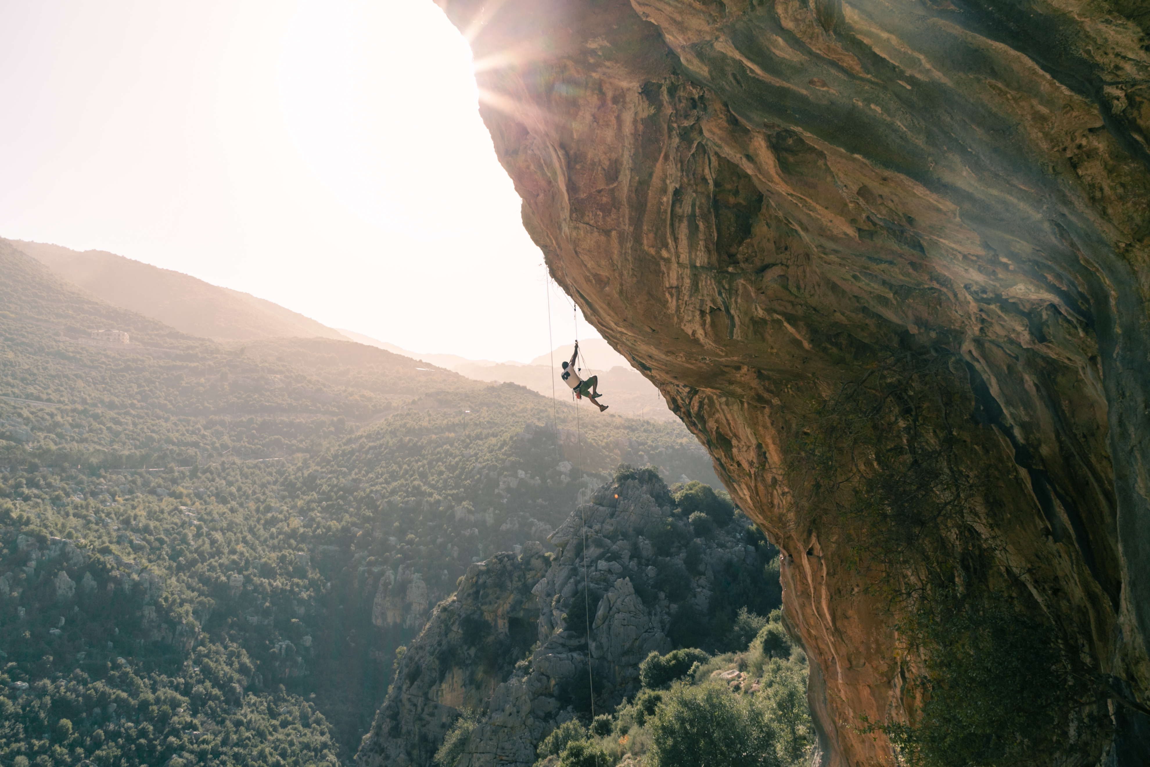 Rock climber climbs down a rock face