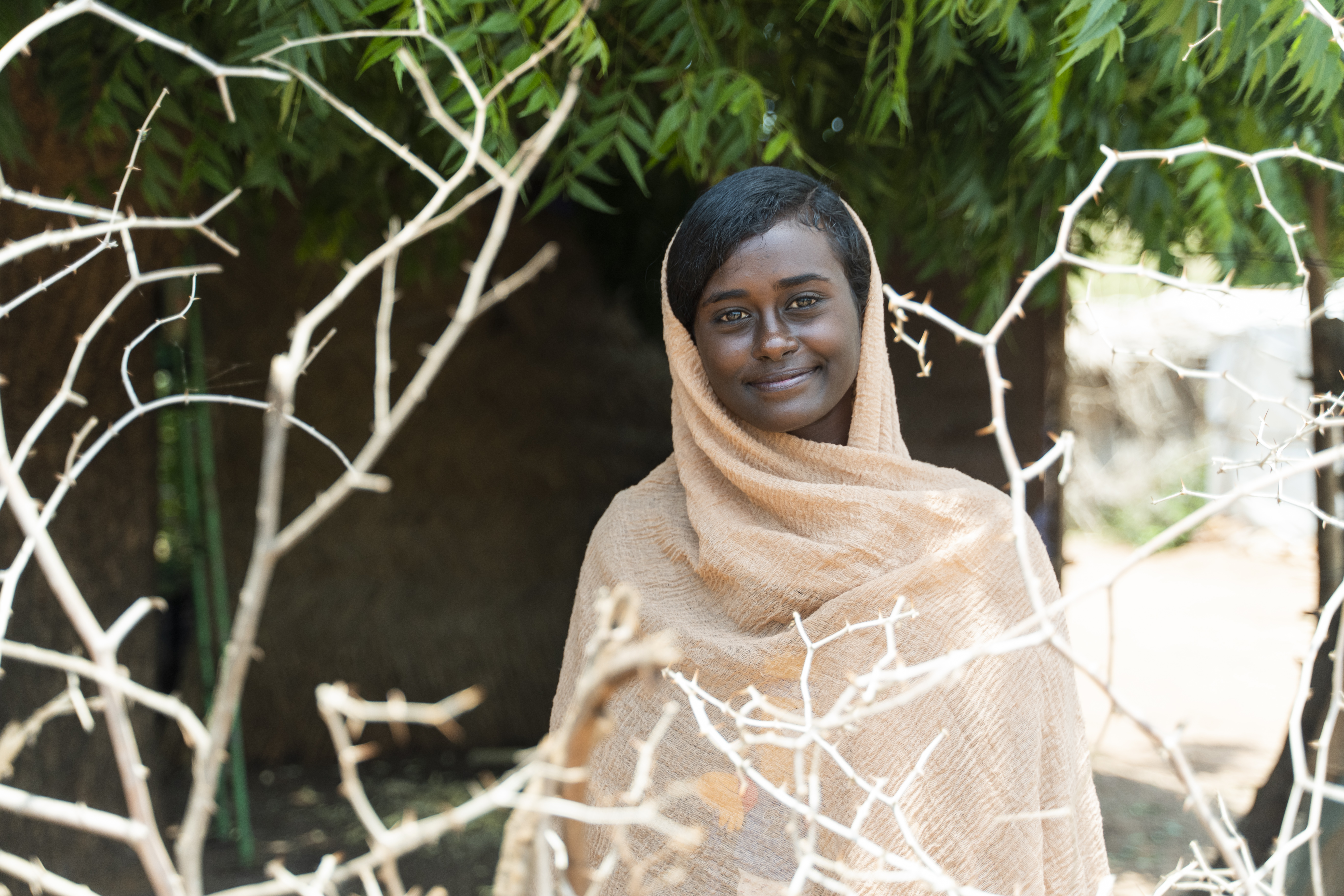 Islam, 21, an internally displaced Sudanese student who was forced to flee Khartoum after the outbreak of conflict in April 2023, stands in front of her grandmother's shelter in Um Rakuba refugee camp, in Doka, Gedaref State, Sudan