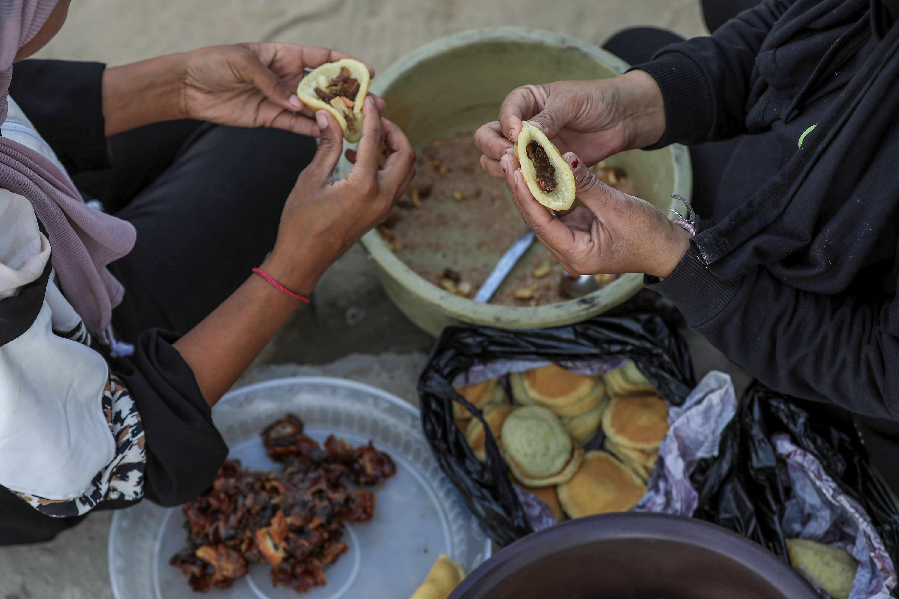 Siham and her sister fill qatayef for frying