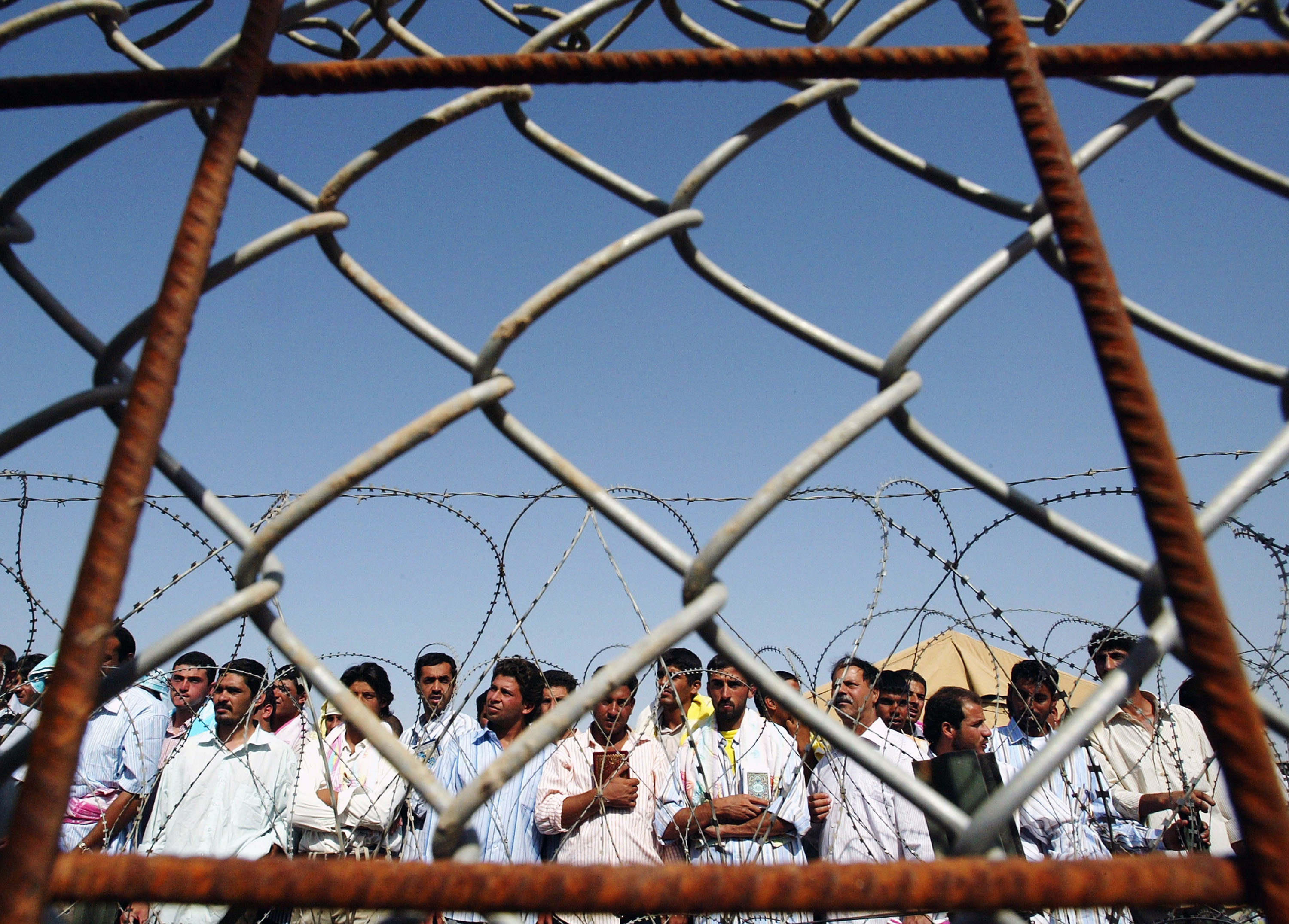 Iraqi prisoners wait to be released at Abu Ghraib prison, west of Baghdad, on June 23, 2006 [Wathiq Khuzaie/Pool/Reuters]