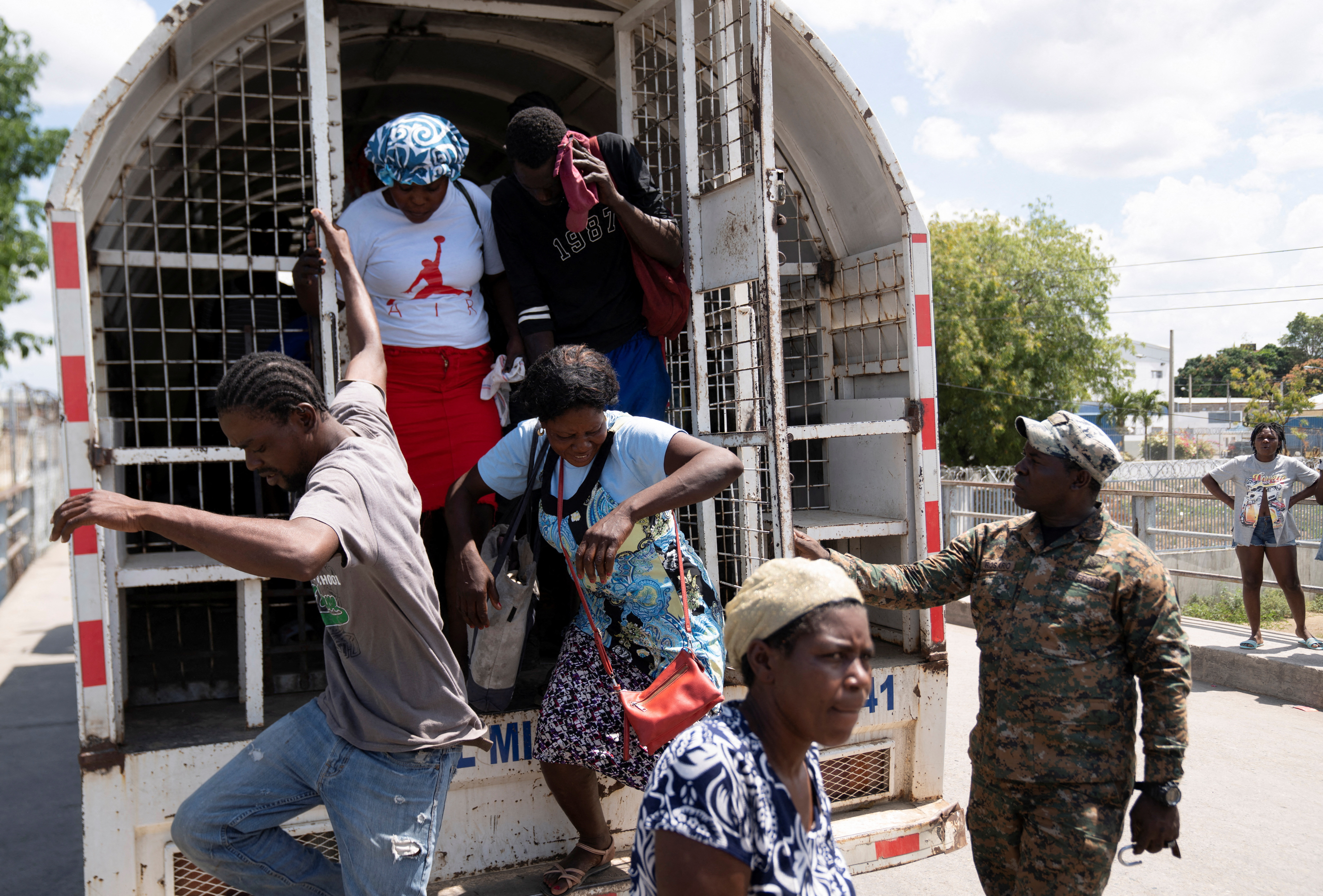 Haitian citizens get off a truck to be sent back to Haiti from the Dominican Republic