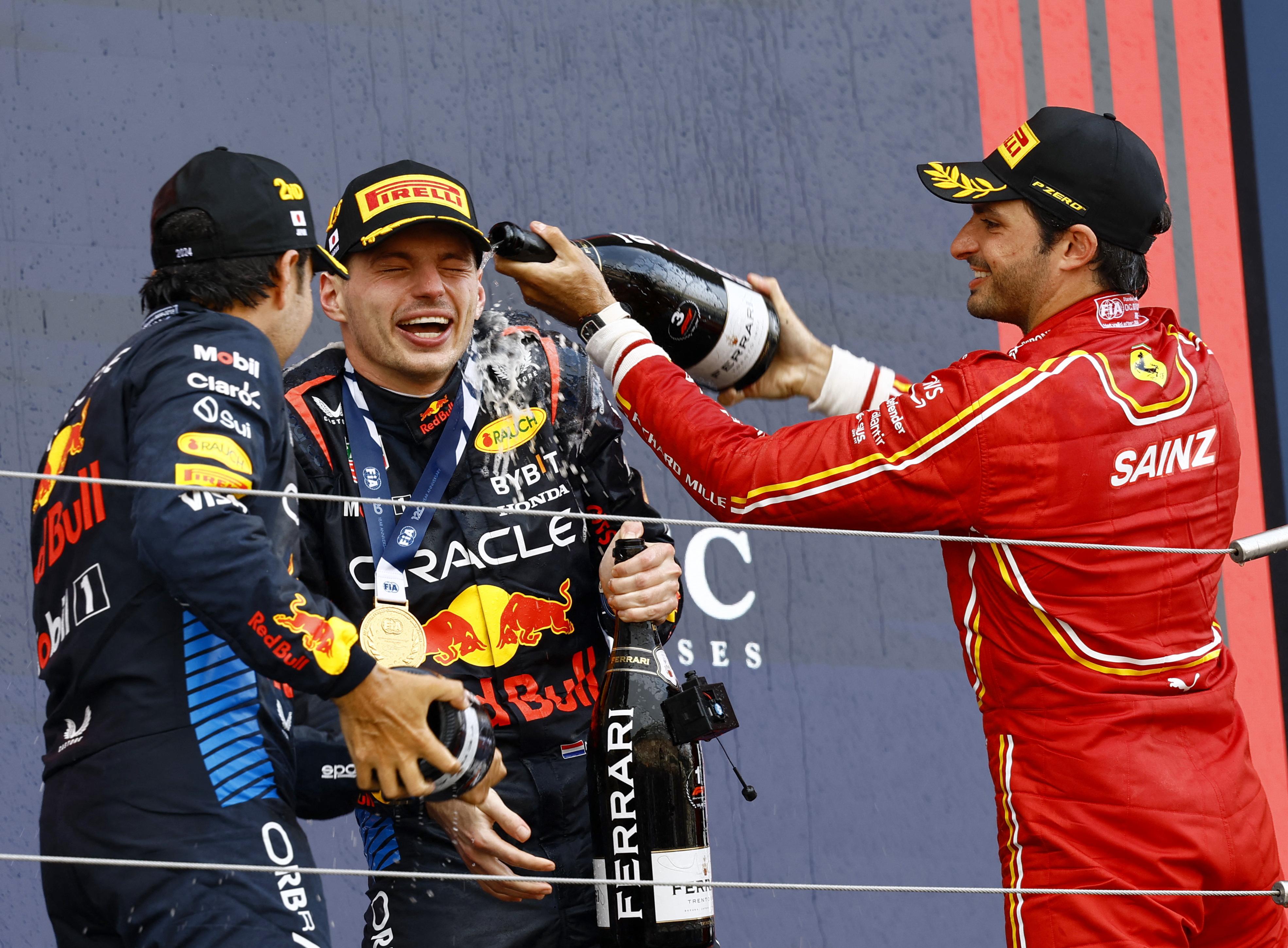 Max Verstappen has champagne sprayed on him on the podium at the Japanese Grand Prix .