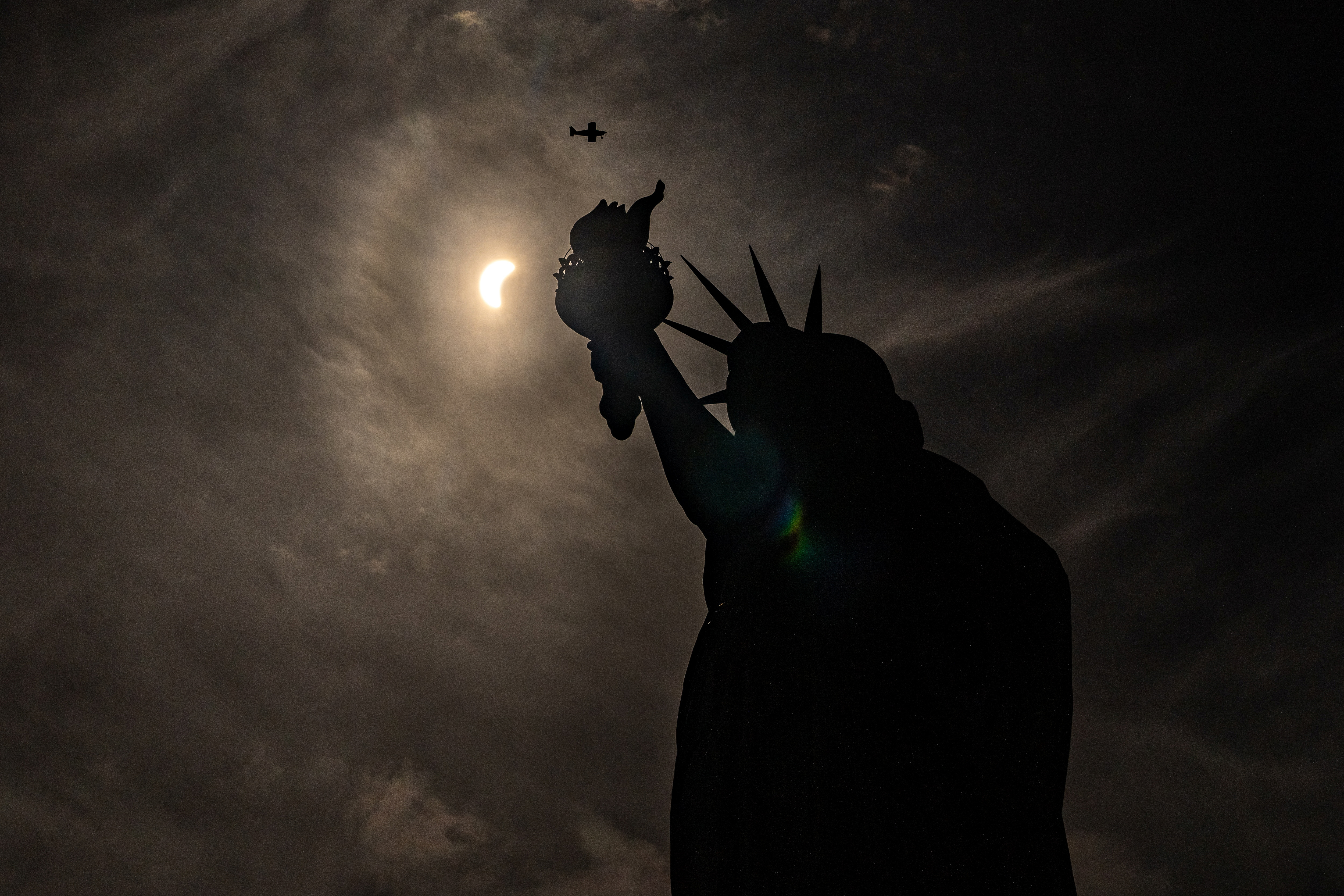 The Statue of Liberty is seen in shadow as the eclipse unfolds