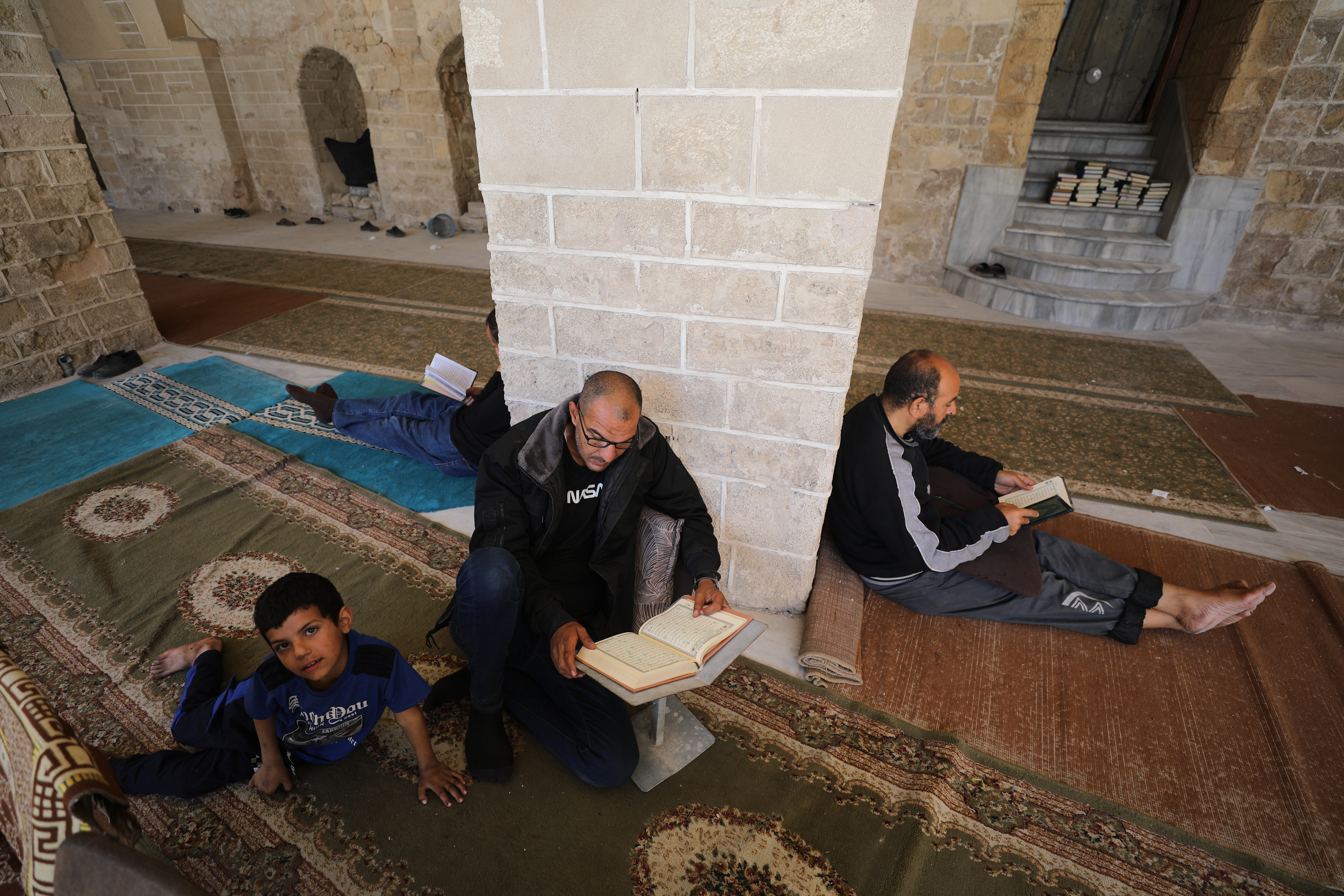 Palestinians gather to read the Holy Qur'an during the last days of Ramadan, in the remaining part of the historic "Great Omari Mosque," also known as the "Great Mosque of Gaza,"