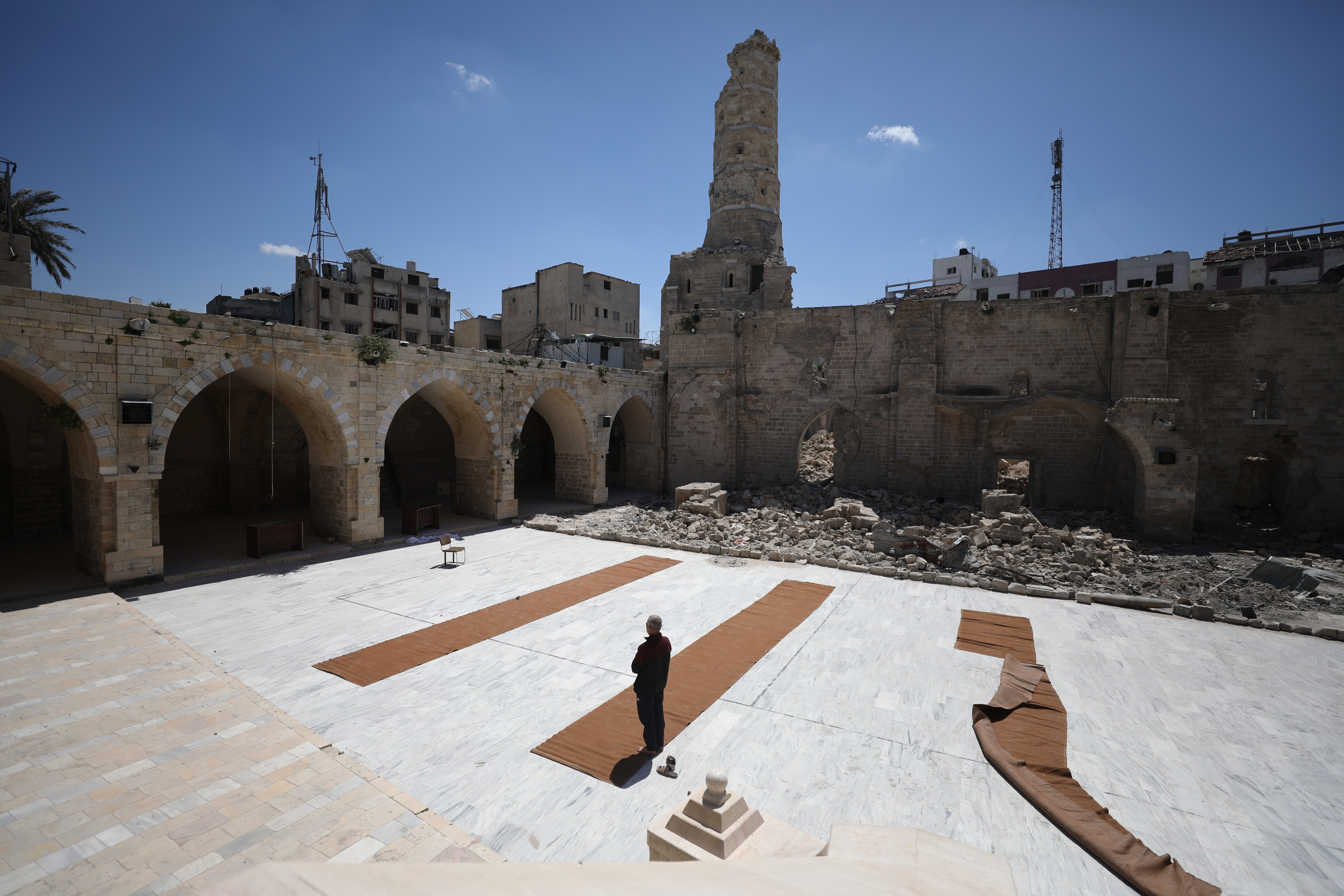 A view of damage as Palestinians gather to read the Holy Qur'an during the last days of Ramadan, in the remaining part of the historic "Great Omari Mosque," also known as the "Great Mosque of Gaza," following its destruction by Israeli military bombardments in Gaza