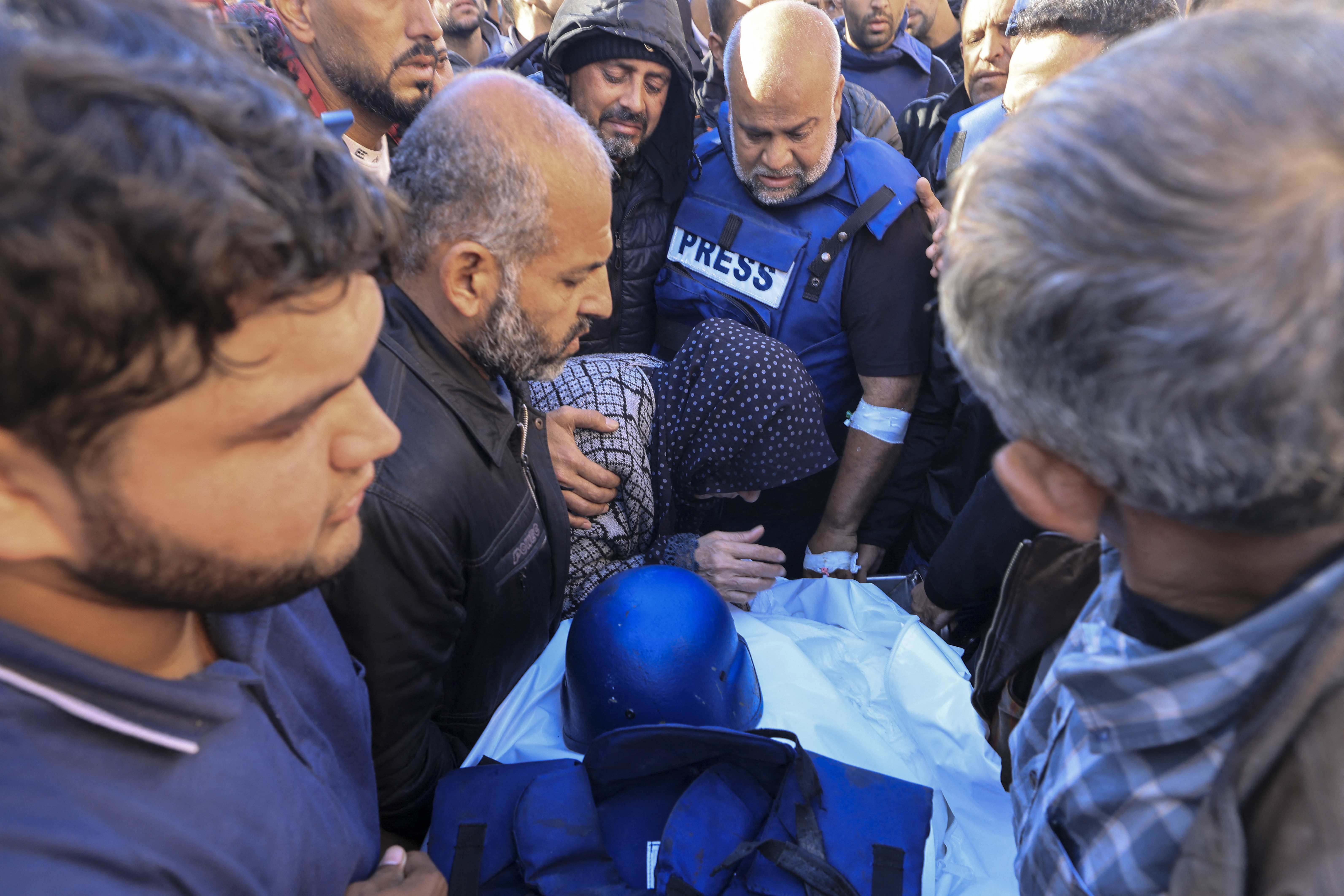 Colleagues and family members mourn over the body of Al Jazeera cameraman Samer Abu Daqa, who was killed during Israeli bombardment, during his funeral in Khan Yunis on the southern Gaza Strip on December 16