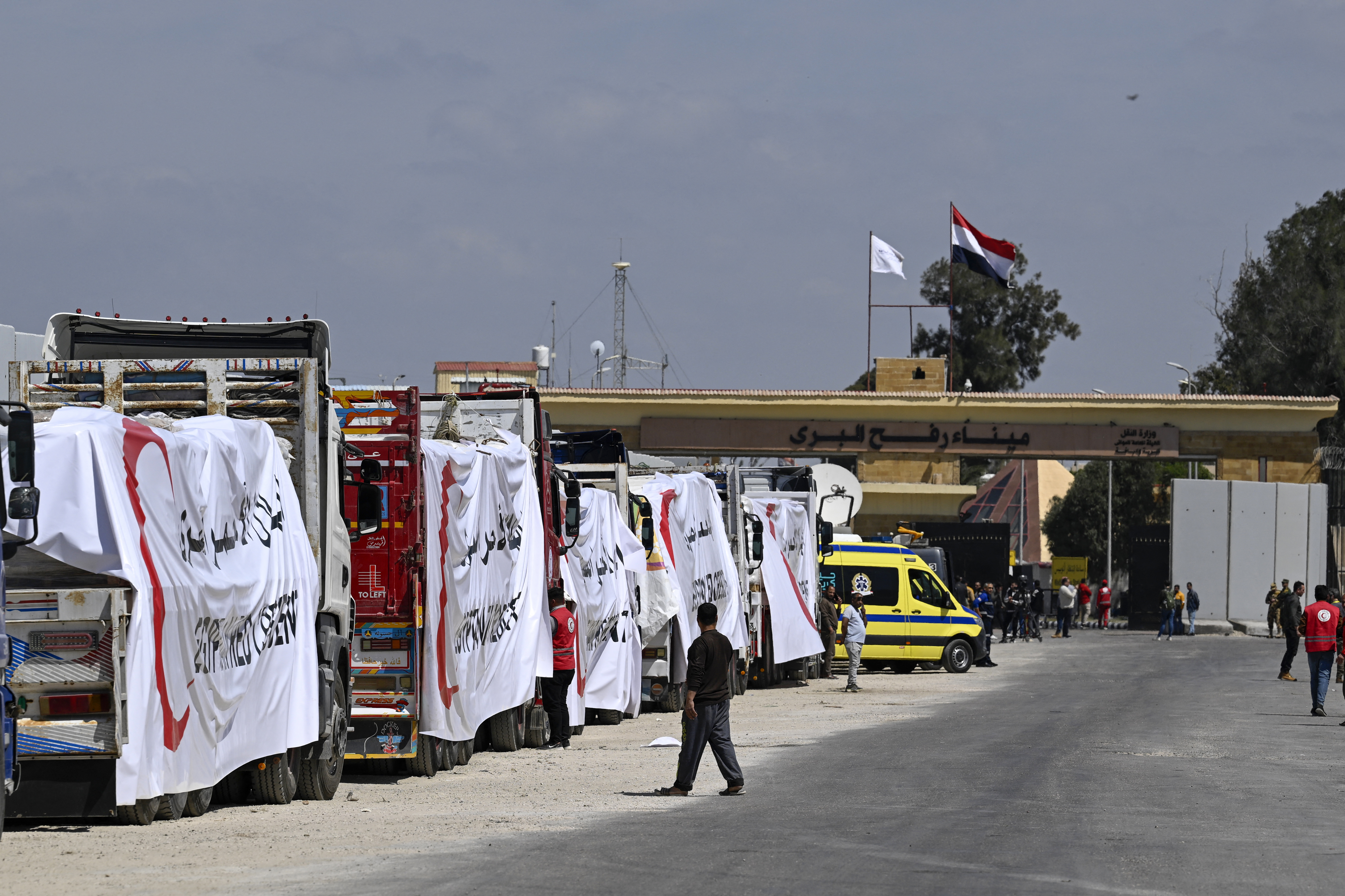 Egyptian Red Crescent trucks loaded with aid queue outside the Rafah border crossing