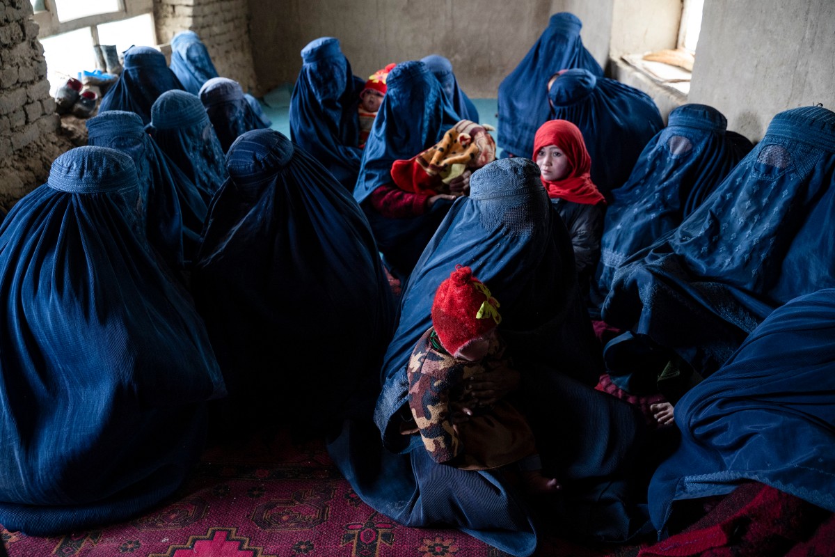 Afghan burqa-clad women and their children waiting to be inoculated.