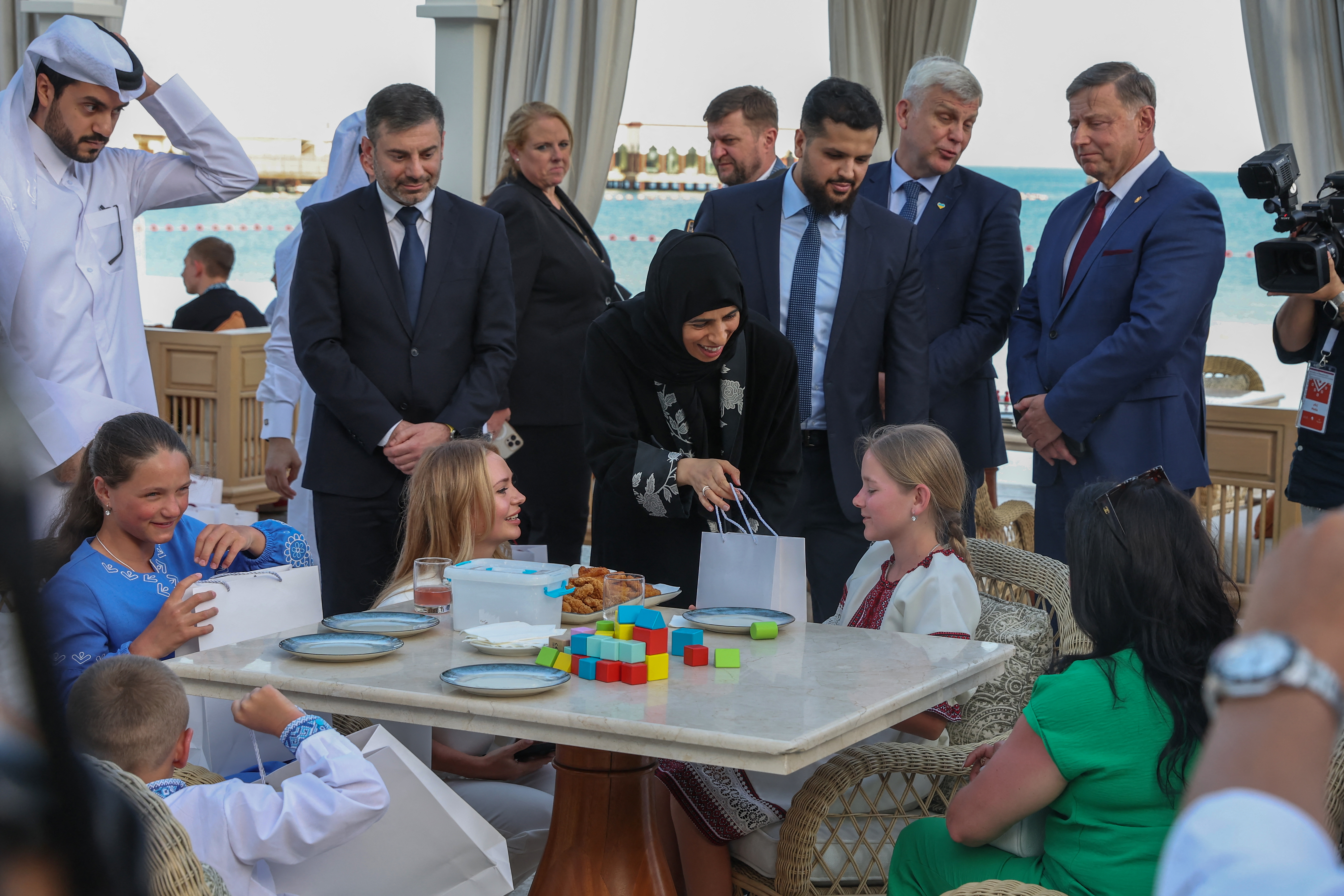 Qatari Minister of State for International Cooperation Lolwah Al-Khater (L) welcomes Ukrainian children and their framilies, flanked to her right by Human Rights Commissioner in the Ukrainian Parliament Dmytro Lubinets in Doha on April 24, 2024.