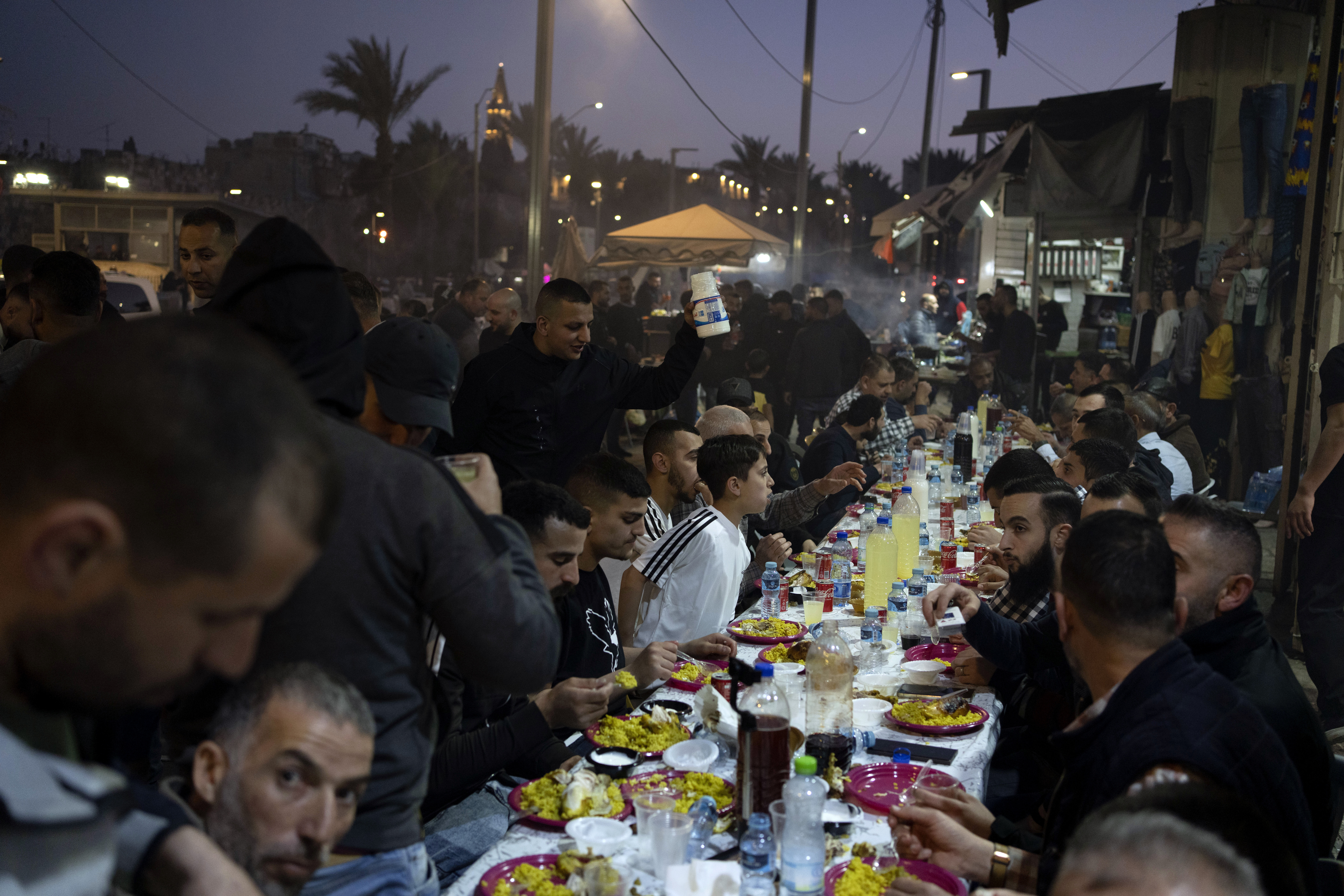 Muslim people break their fast with the Iftar meal after the last Friday prayers of the Muslim holy month of Ramadan, outside the Old City of Jerusalem, Friday, April 5