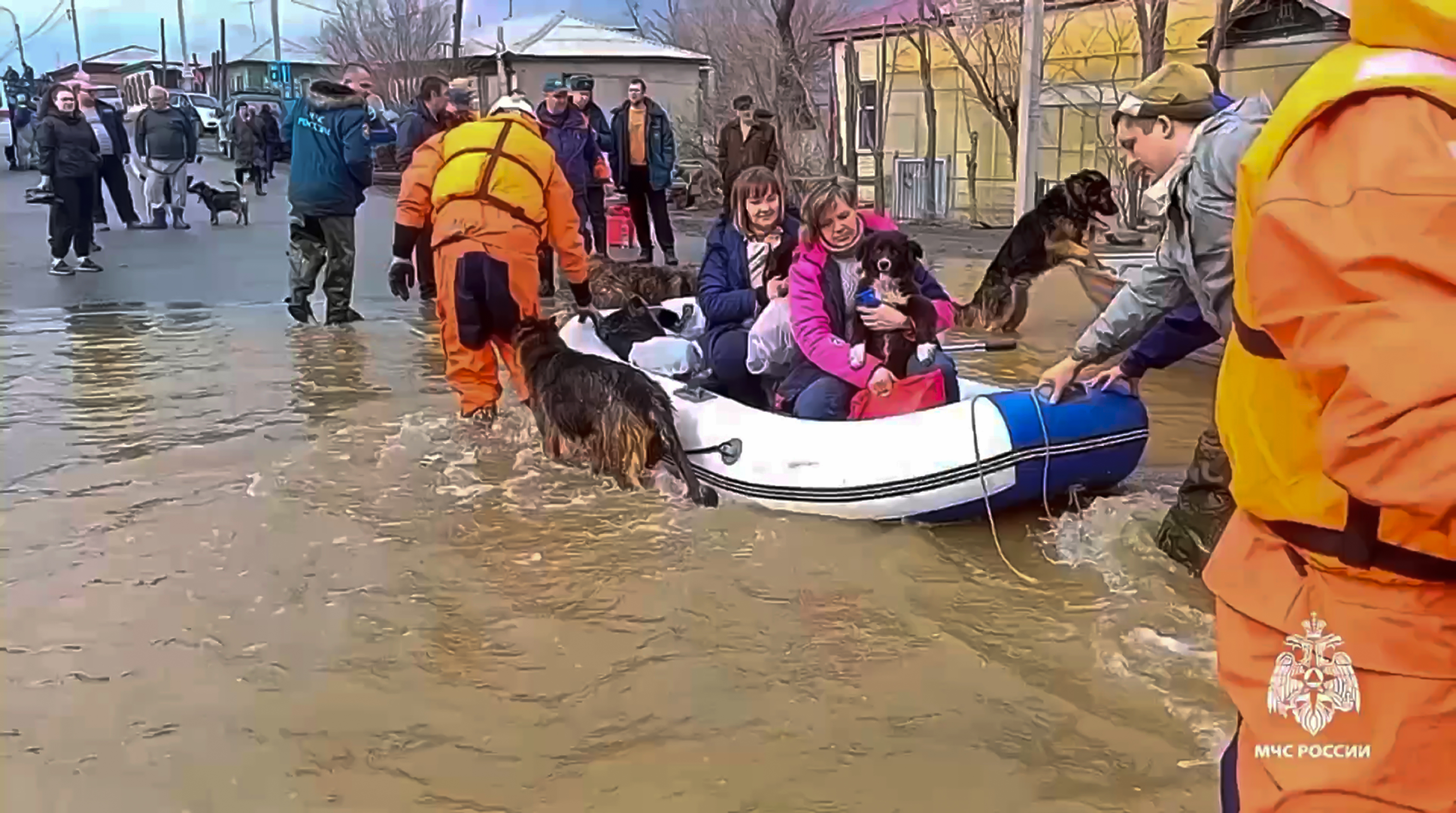In this image taken from a video released by the Russian Emergency Ministry Press Service on Saturday, April 6, 2024, emergency workers evacuate local residents with their pets after a part of a dam burst causing flooding, in Orsk, Russia. Floods hit a city in the Ural Mountains areas after a river dam burst there, prompting evacuations of hundreds of people, local authorities said. The dam breach in Orsk, a city less than 20 kilometers north of Russia's border with Kazakhstan, occurred on Friday night, according to Orsk mayor Vasily Kozupitsa.