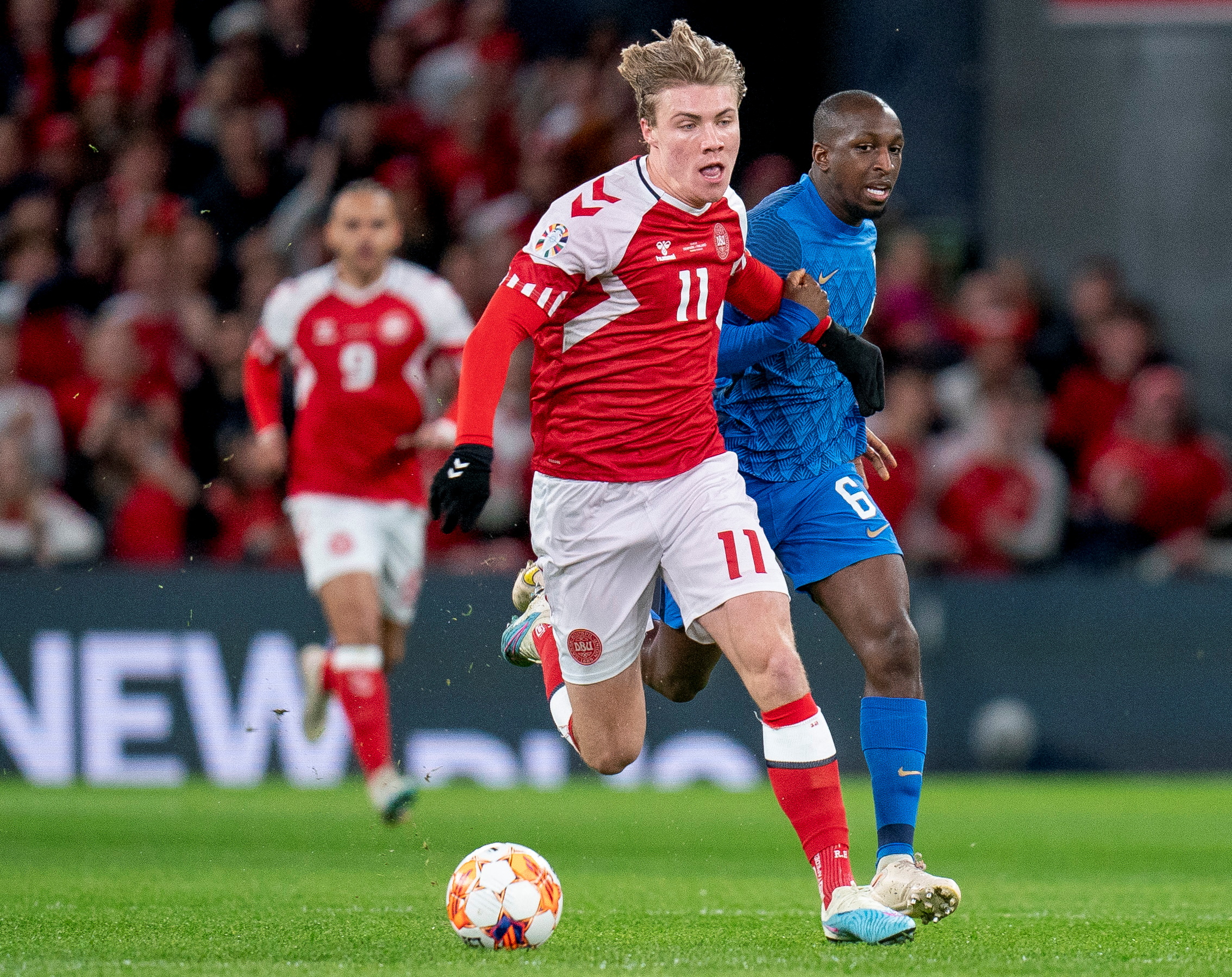 Football player dribbles football towards goal.