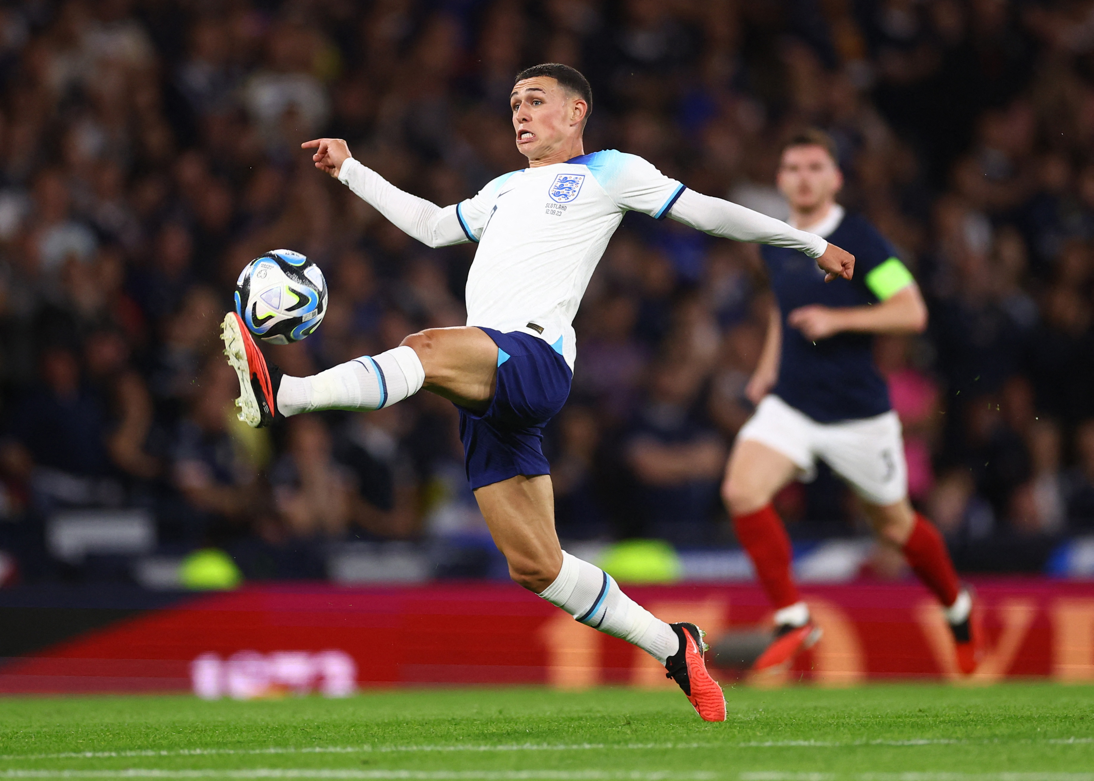 Footballer catches ball on the end of his foot.