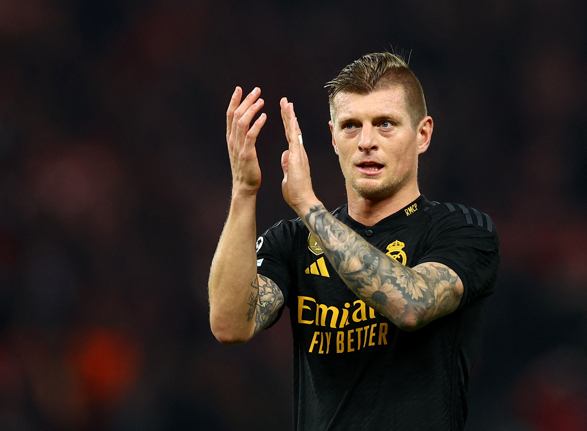 Football player claps for supporters after game.