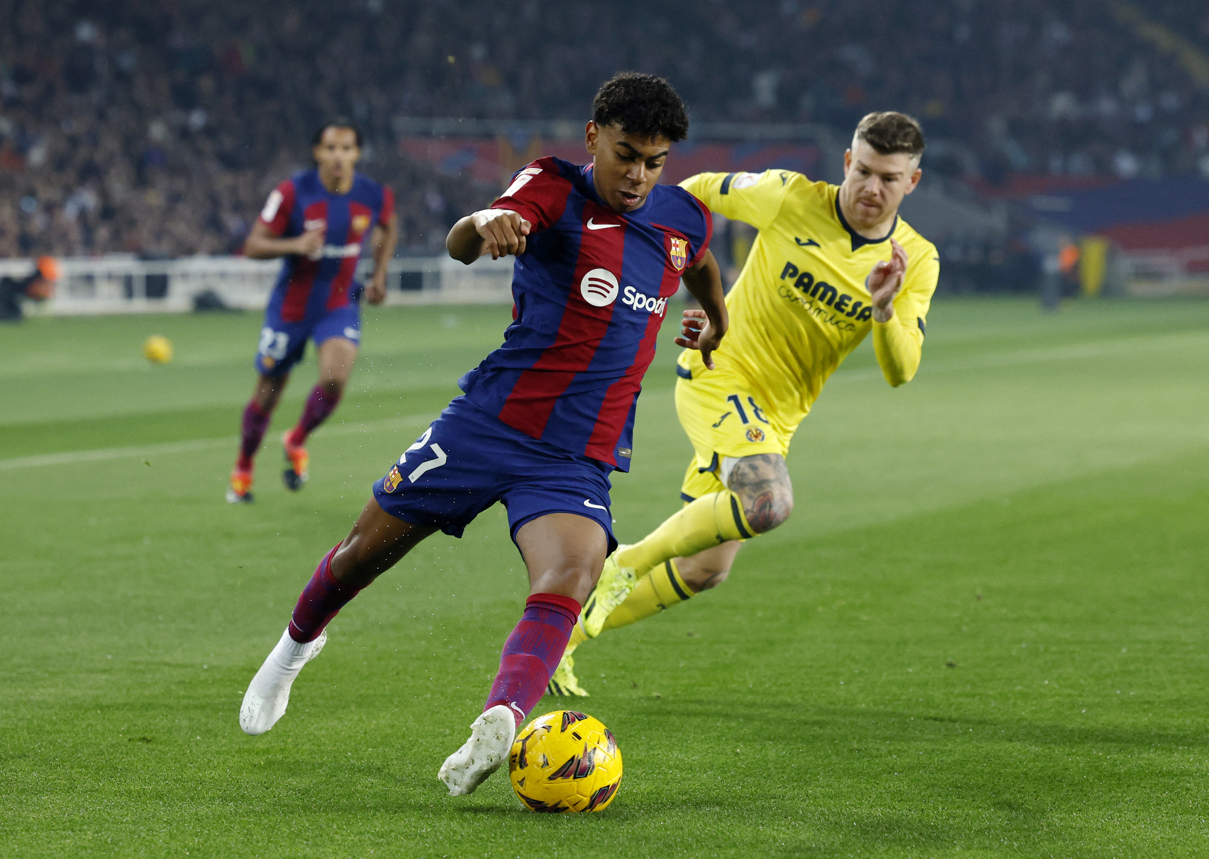 Football player dribbles around defender.